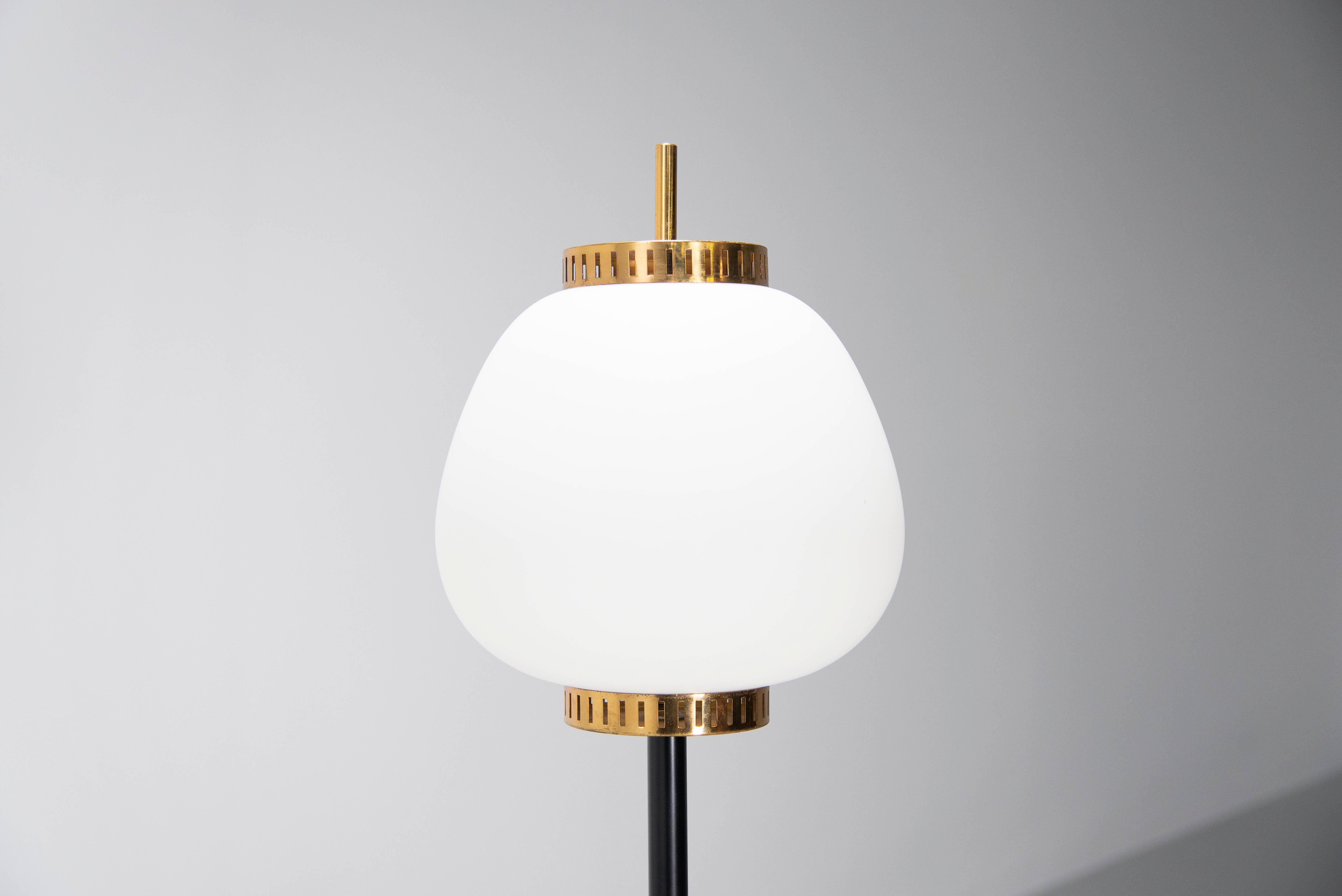 Very nice lantern floor lamp designed by Bruno Gatta and manufactured by Stilnovo, Italy 1950. This floor lamp has a 50s lantern shape and a round marble carrara marble base, a black painted stem and a milk glass shade with brass fittings. The lamp