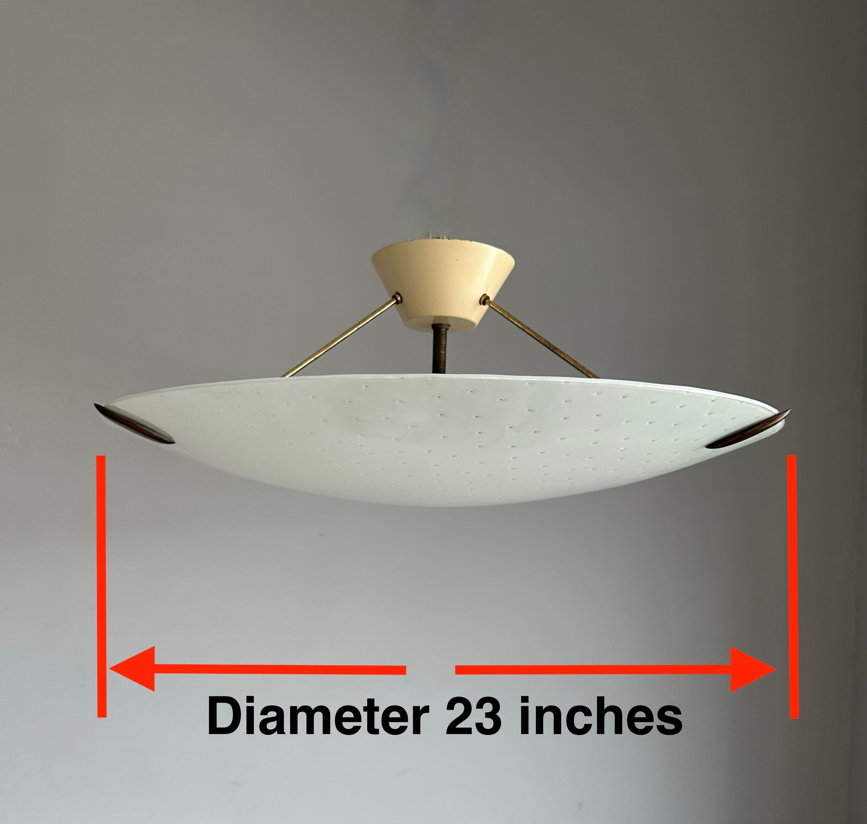 Grande plafoniera a 3 luci in stile MidCentury Modern di Stilnove con paralume in ottone e vetro artistico circolare con motivo a fori.

Questo ciondolo vintage ha un aspetto e una sensazione bellissimi e difficilmente troverai un apparecchio di