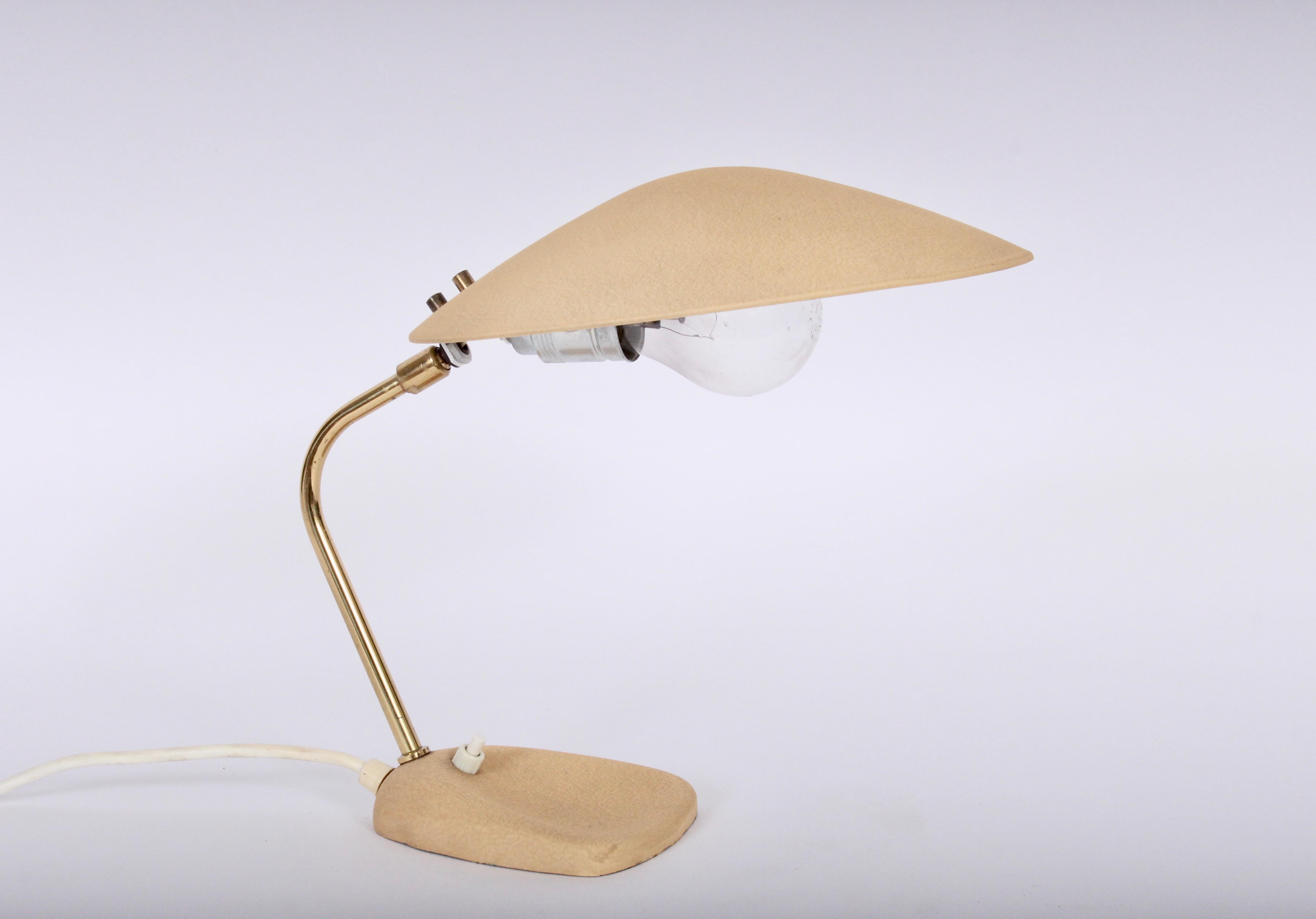 European Modern Stilnovo style adjustable enameled steel saucer shade table lamp. Featuring an adjustable Brass plated arched swing arm stem, enameled (10W) Steel swing saucer shade in textured Khaki Beige on rounded, balanced triangular base (5.5 x