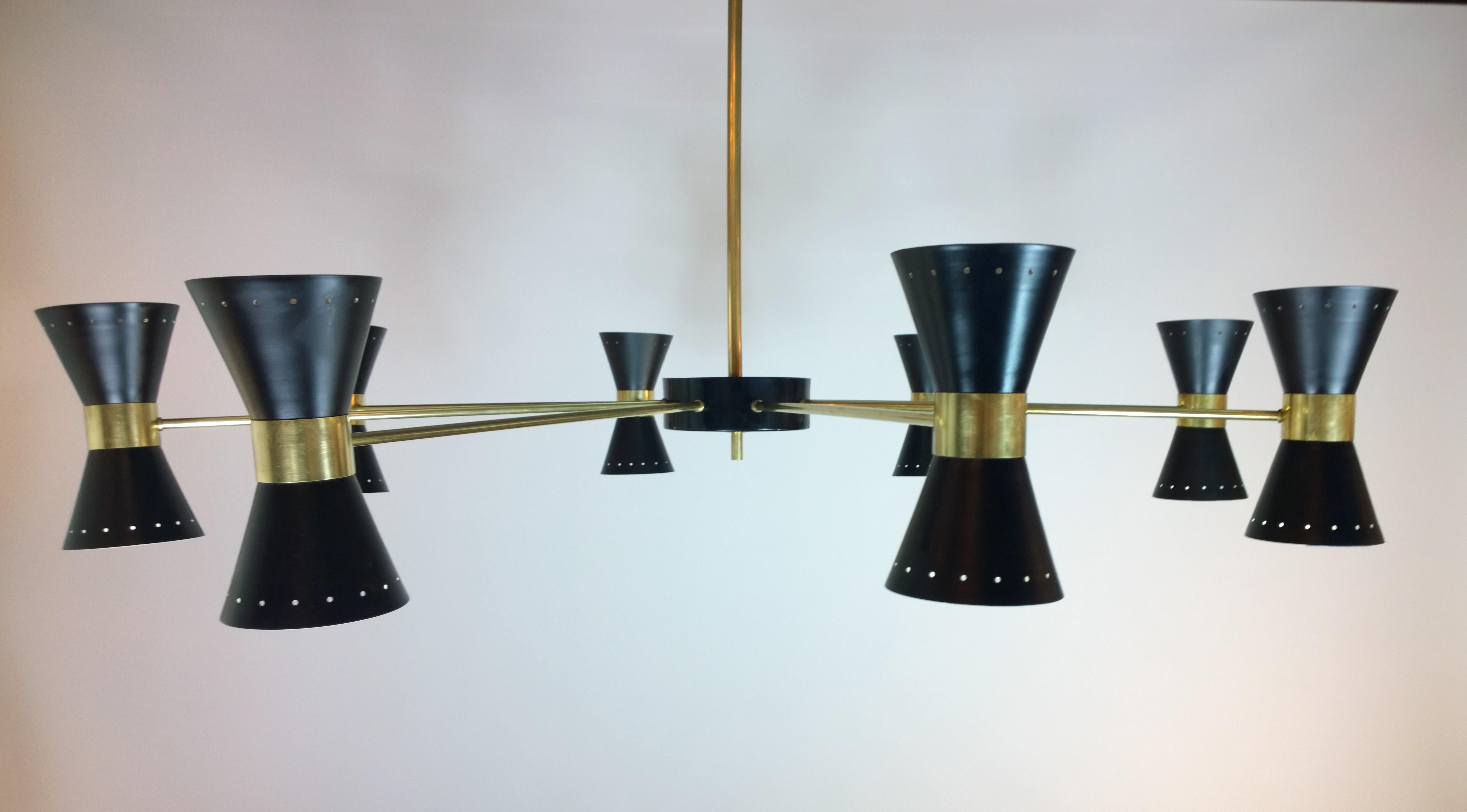Offered is a Mid-Century Modern Italian vintage Stilnovo style brass eight-arm black enameled perforated brass double cone (16 socket) chandelier. This stunning vintage Mid-Century Modern Italian Stilnovo style light fixture / monumental chandelier