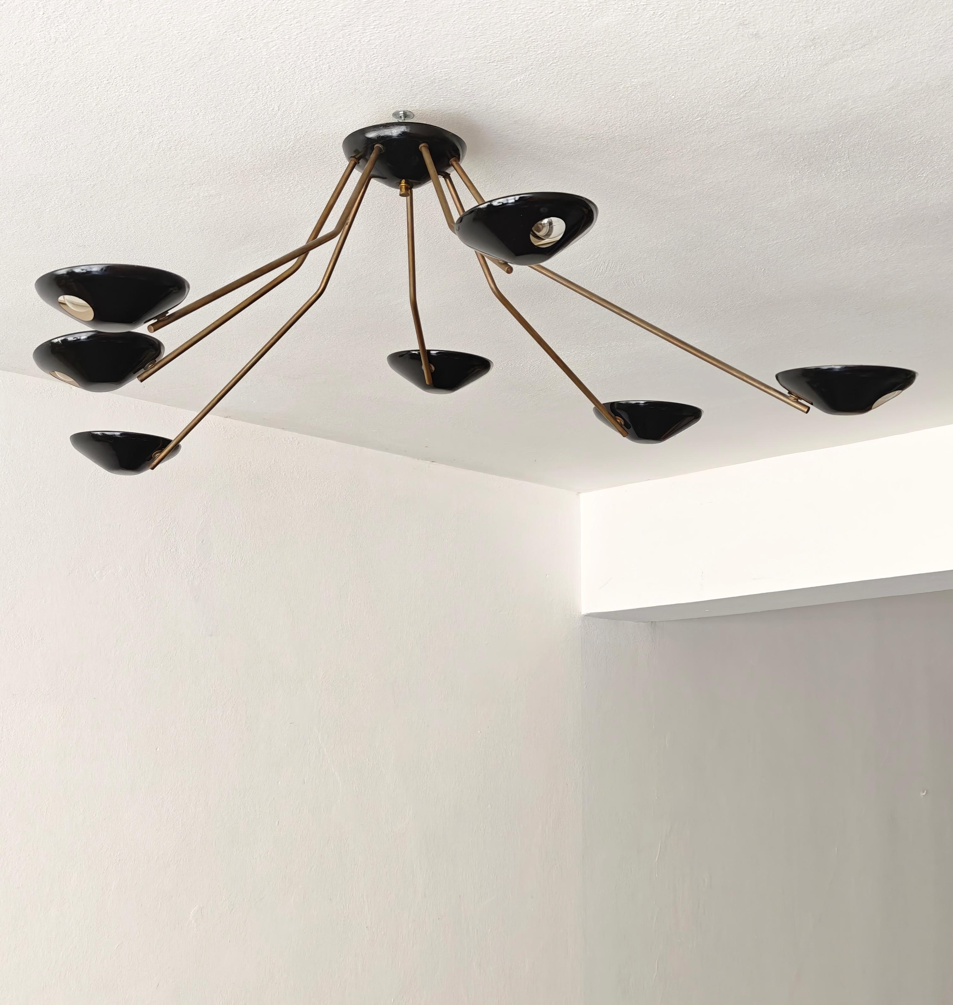 Rare en son genre, ce plafonnier. Sept bras en laiton avec un diffuseur en aluminium laqué noir. Comme vous pouvez le constater, les bras ne sont pas droits mais présentent une légère courbure, ce qui le rend vraiment spécial. Elle ne passe pas