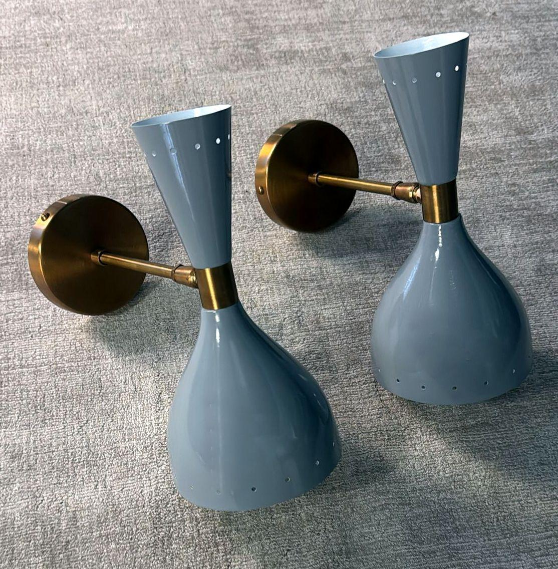 Please take a moment to read the full description. We've included detailed technical and historical information to ensure the authenticity and quality of our pieces.
Iconic and elegant pair of Italian wall sconces in brass, featuring two opposing