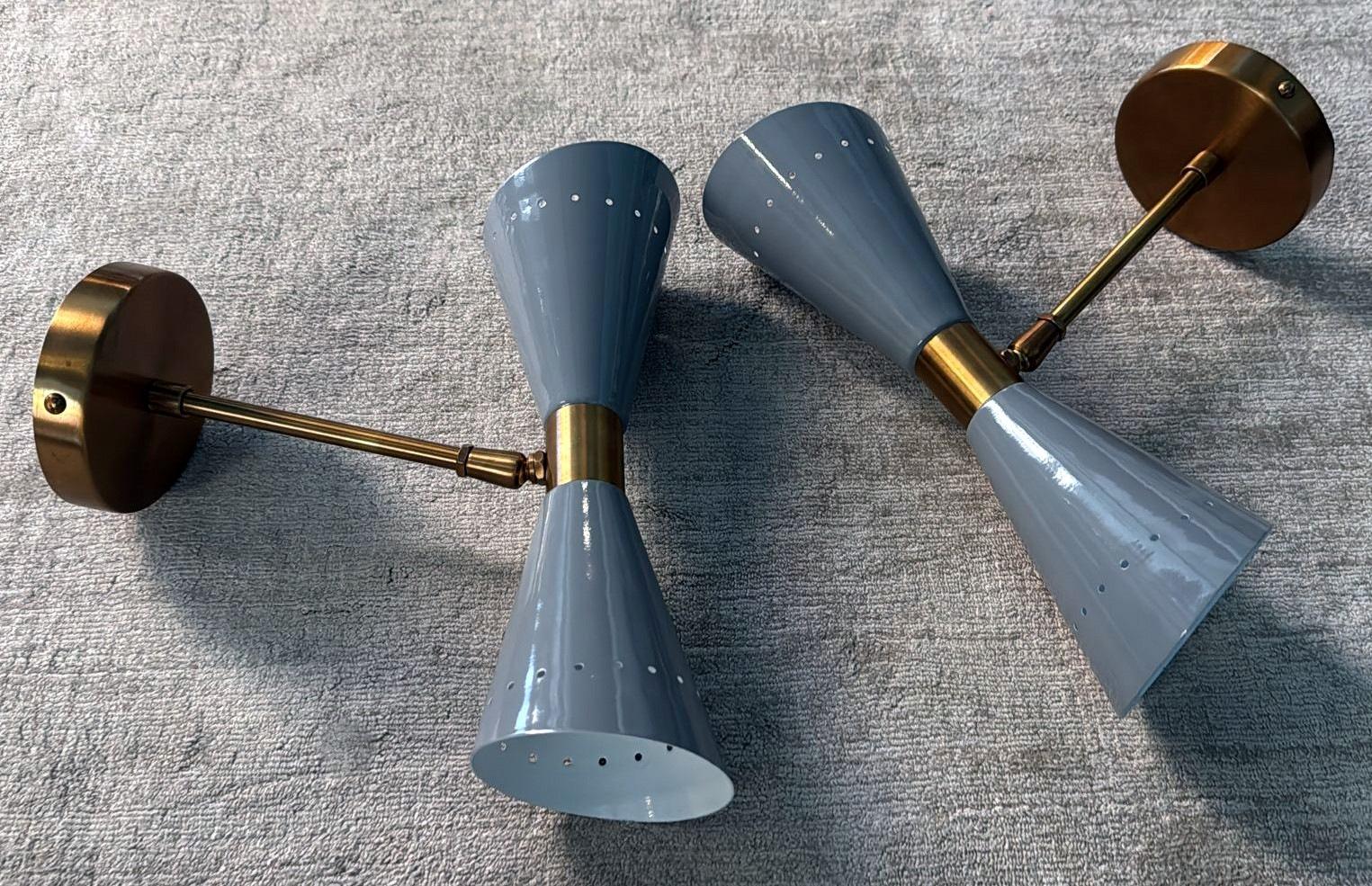 We kindly invite you to read the entire description, as it includes both technical and historical information that will help ensure the authenticity of our pieces.
Iconic and refined pair of wall sconces made of brass, featuring two opposing
