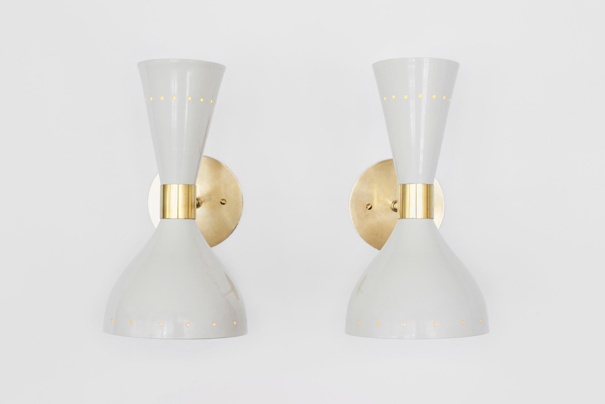 Great pair of Italian metal sconces in the style of Stilnovo, newly produced in Italy. Off-white metal shade with brass detailing and back-plate. Sconces shine both up and down light. Wired to American standards.
 