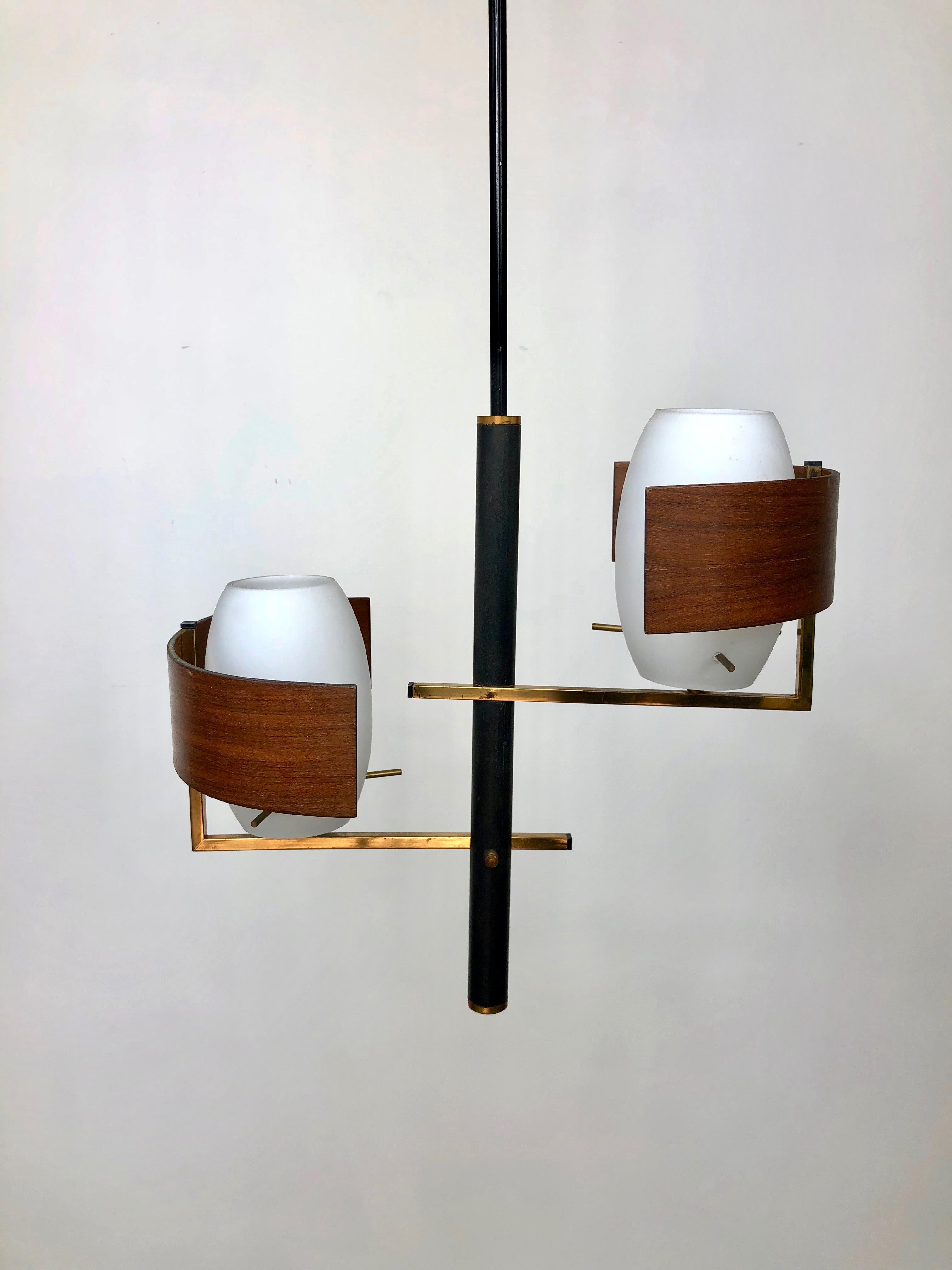 Italian modernist chandelier with 2 white opaline glass shades embellished with brass and teak frame and details. Typical modernist piece of the 1960s.
.  