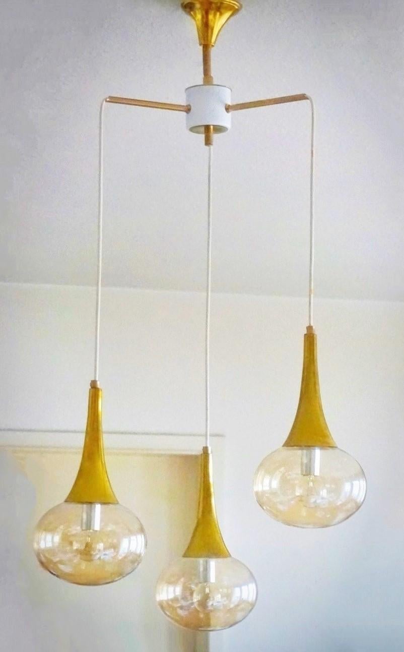 Stilnovo suspension chandelier with three globes in amber hand blown glass, brass and enameled metal structure, Italy, 1960s.
It takes three E14 crew bulbs up to 60watt each bulb.
Measures:
Height 36