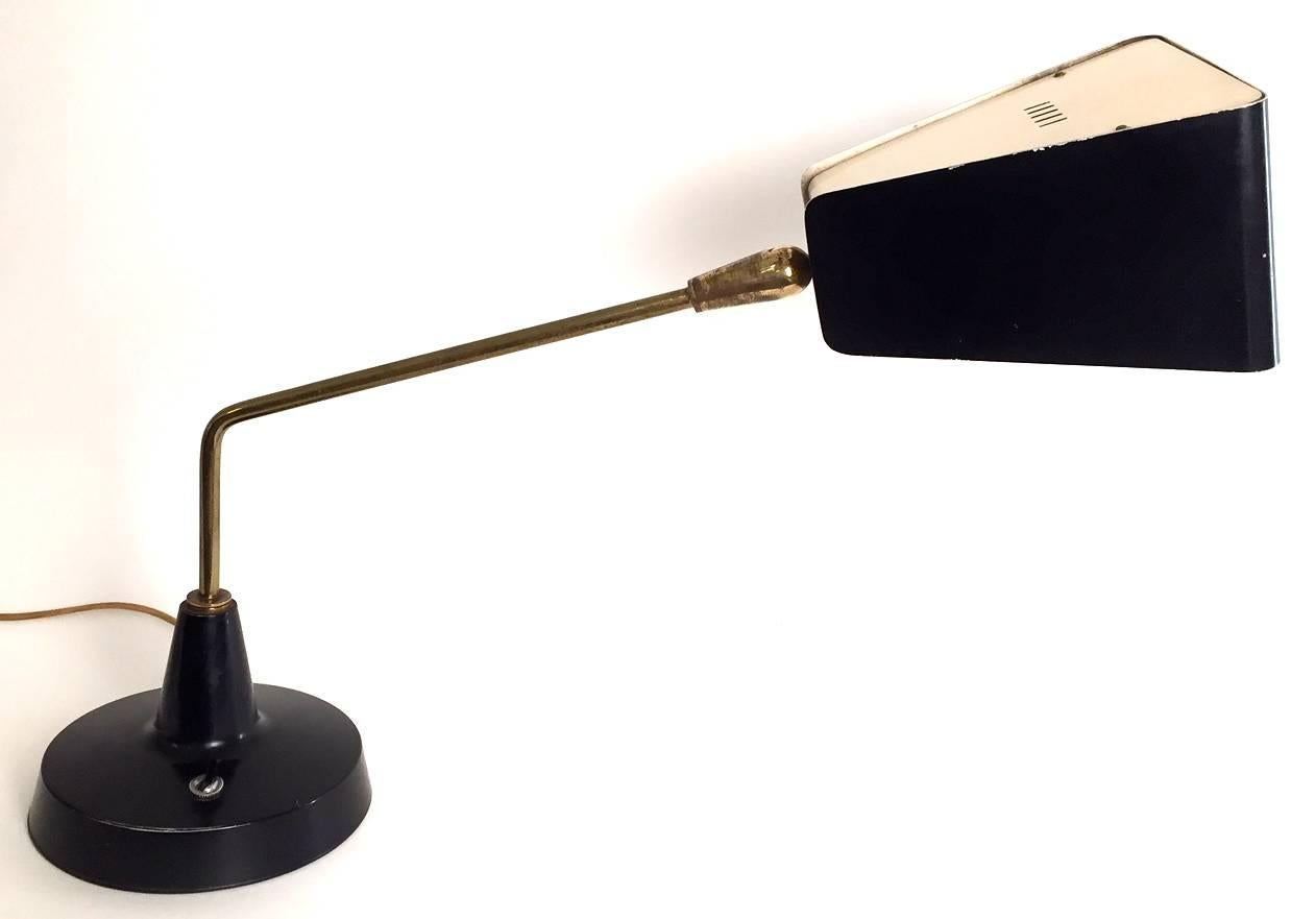 A very rare Stilnovo table lamp. Signature and label. Enameled metal and adjustable arm and reflector. Excellent condition.Free shipping is provided.