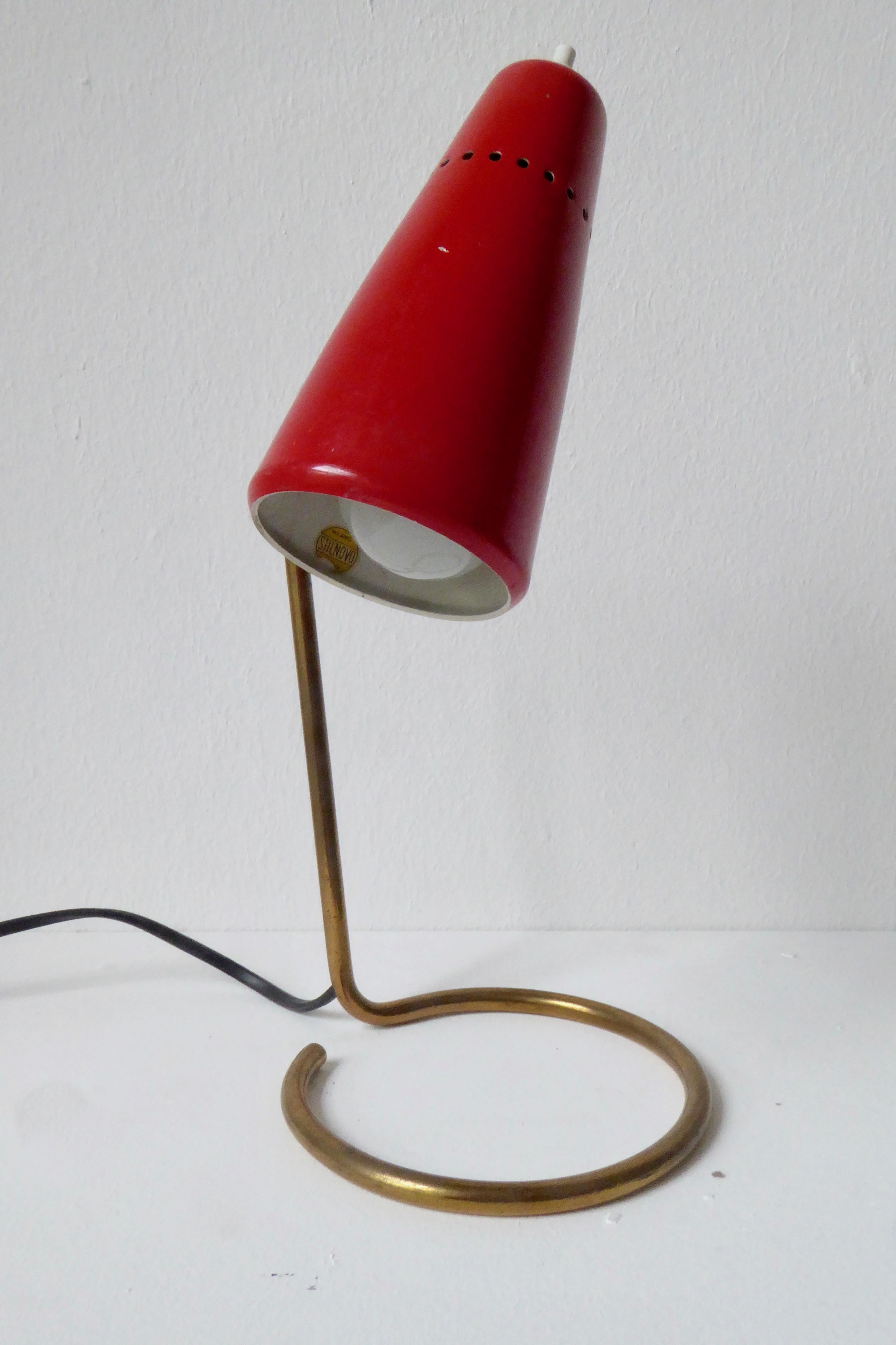 Stilnovo table lamp. Brass base and swiveling red cone. Shade inside with round Stilnovo sticker. Measures: Diameter shade 7cm.