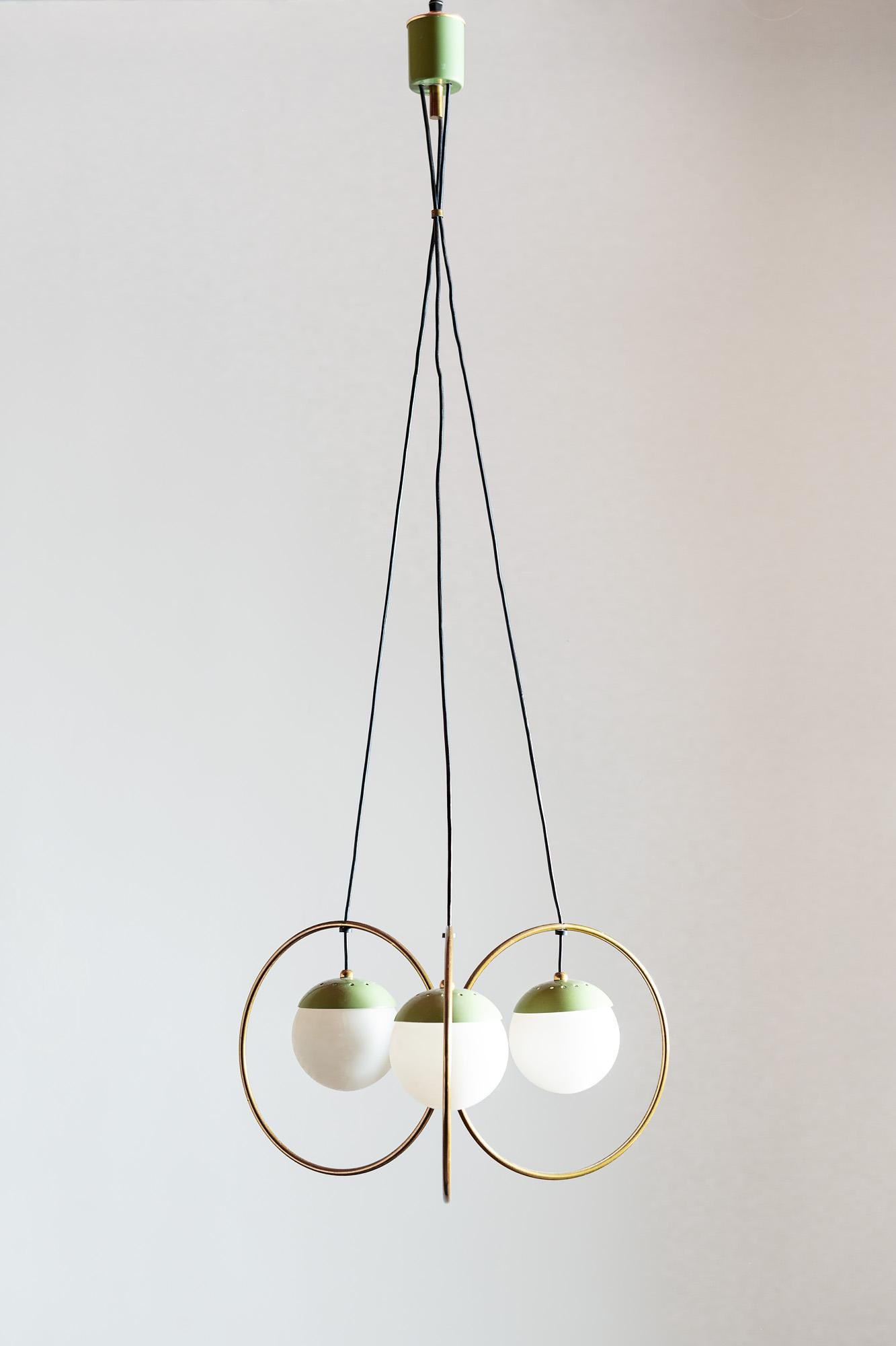 Rare three ball chandelier in brass with green enamel accents and opaque glass globe diffusers. In the style of Stilnovo, Italy, 1950s.