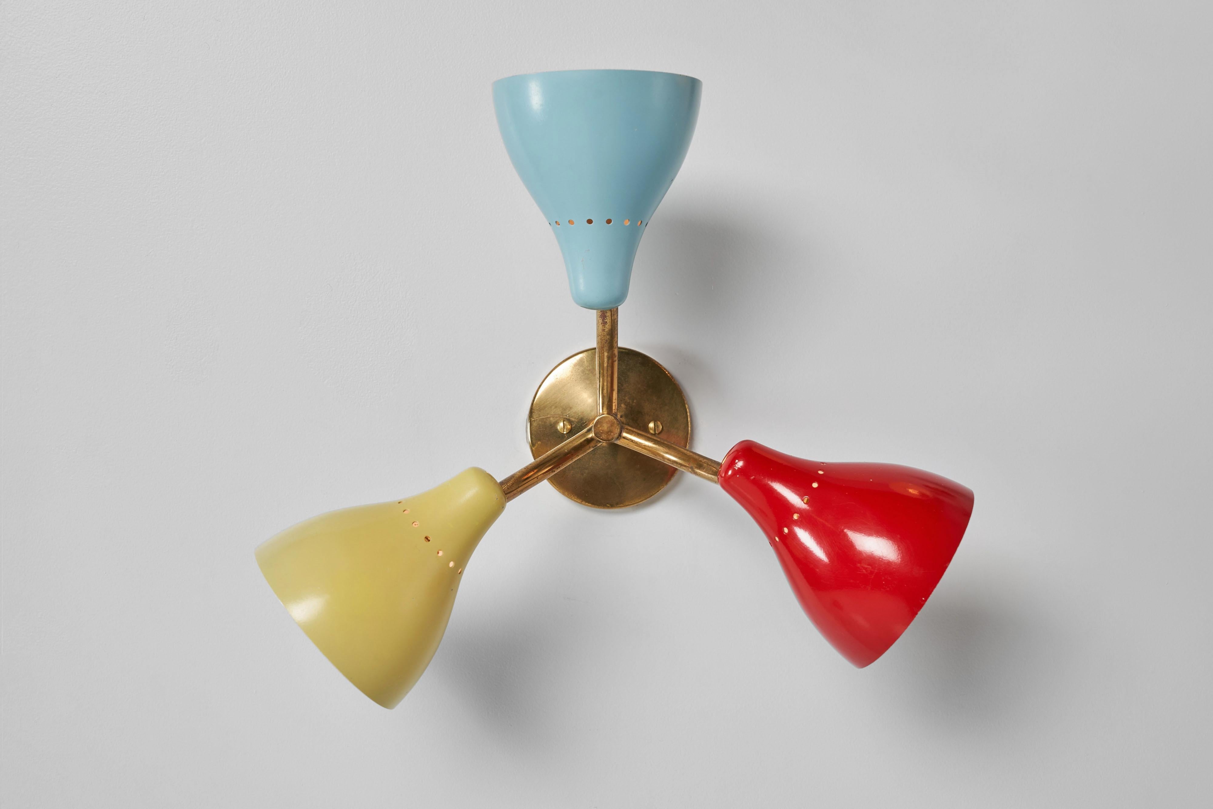 Playful Stilnovo triple shaded ceiling or wall lamps manufactured in Italy in 1950. You can use them as wall or ceiling lights, and the shades are adjustable, letting you control the light just the way you want. The lamps have brass arms and