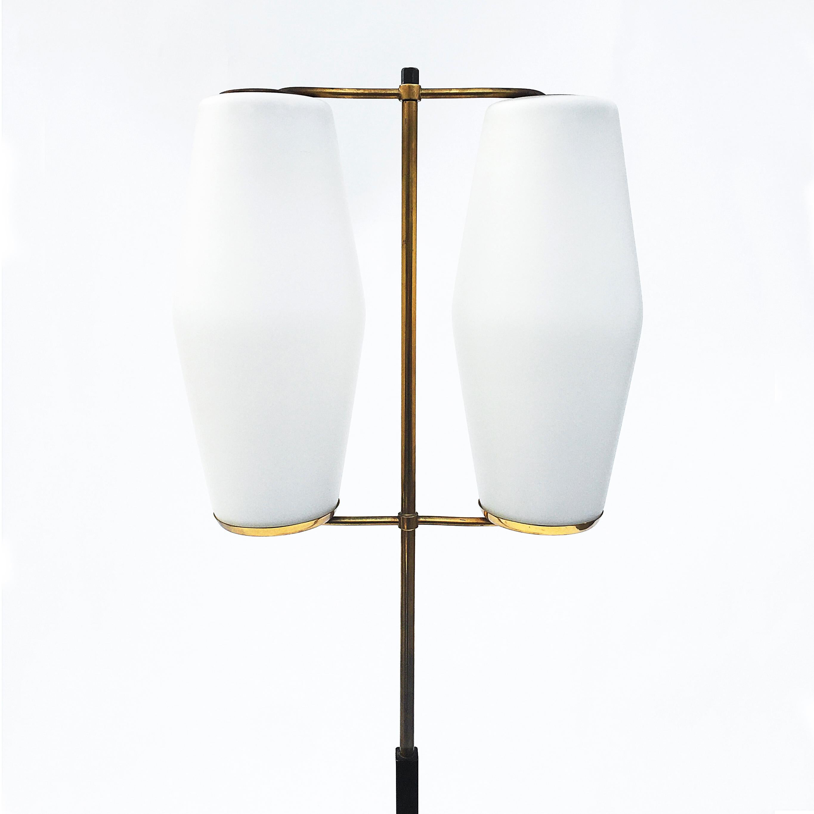 Stilnovo floor lamp on black enamelled pole and marble base supporting in brass finishing’s two frosted white shades.