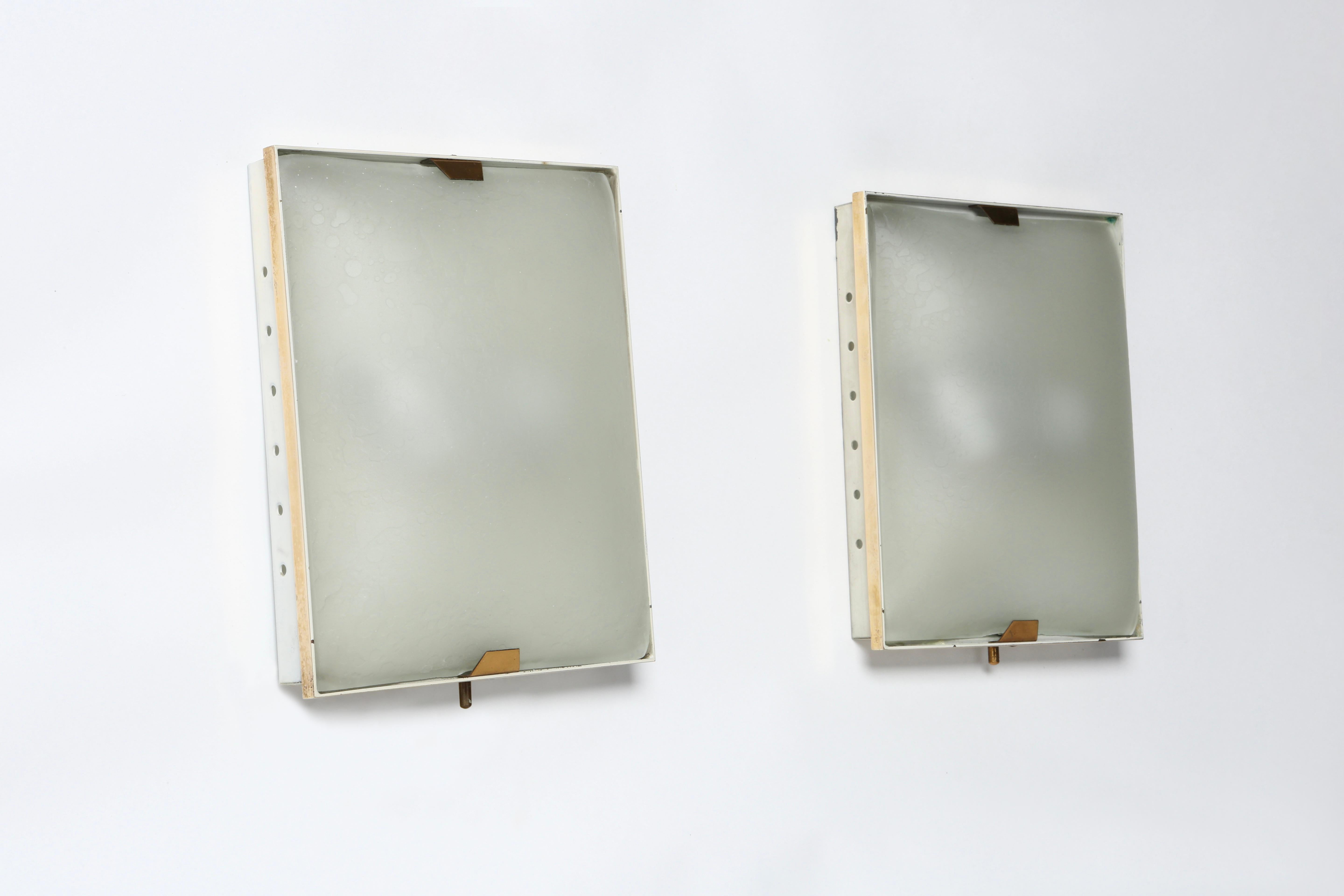 Stilnovo sconces, a pair.
Designed and manufactured in Italy 1960s.
Textured glass, brass, enameled metal.
