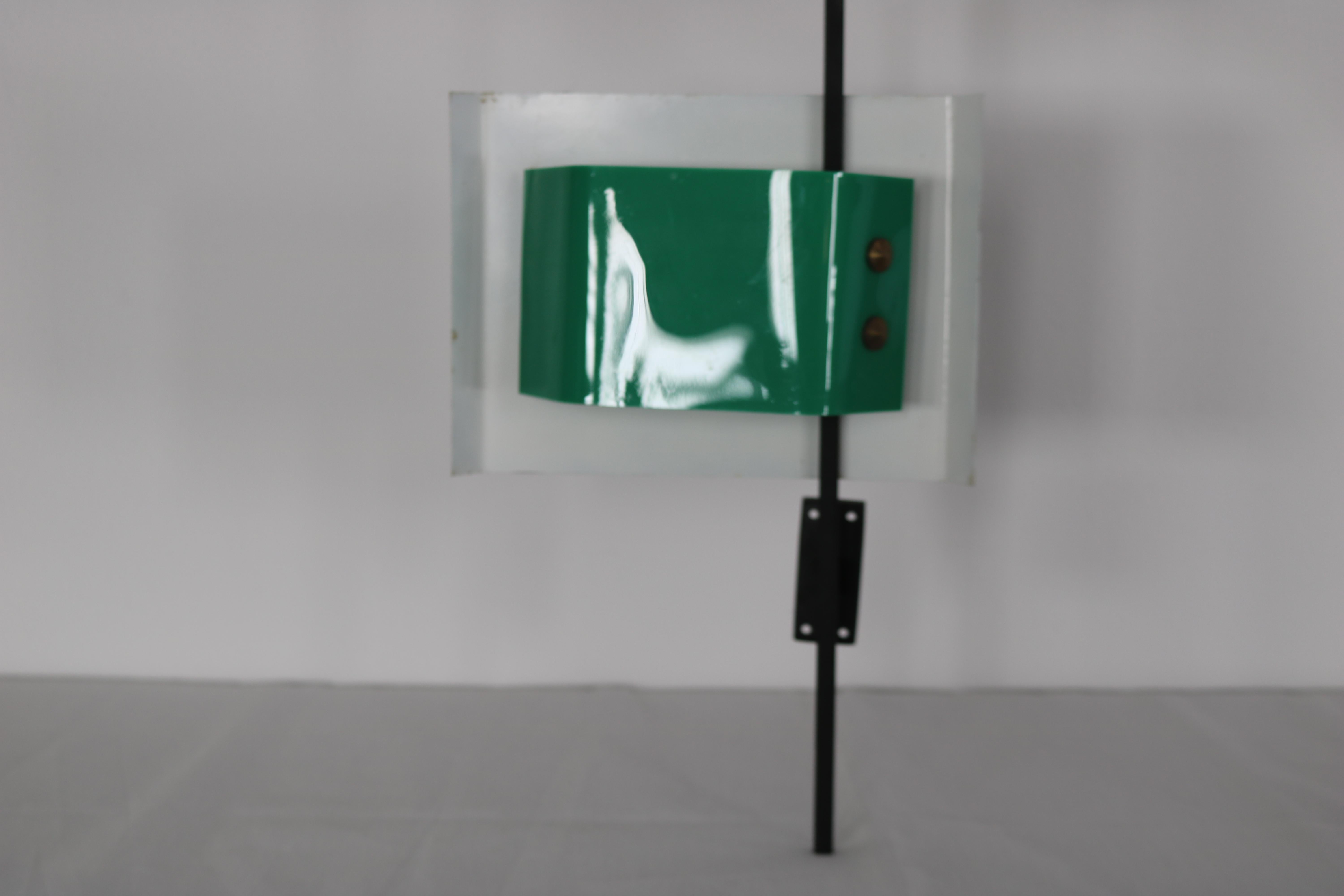 Wall lamp designed and made by Stilnovo, Italy, 1955. Modernist wall lamp with black lacquered arm, an off white lacquered shade, green plexiglass diffuser and brass details. This lamp gives very nice light when lit and is more of a wall sculpture
