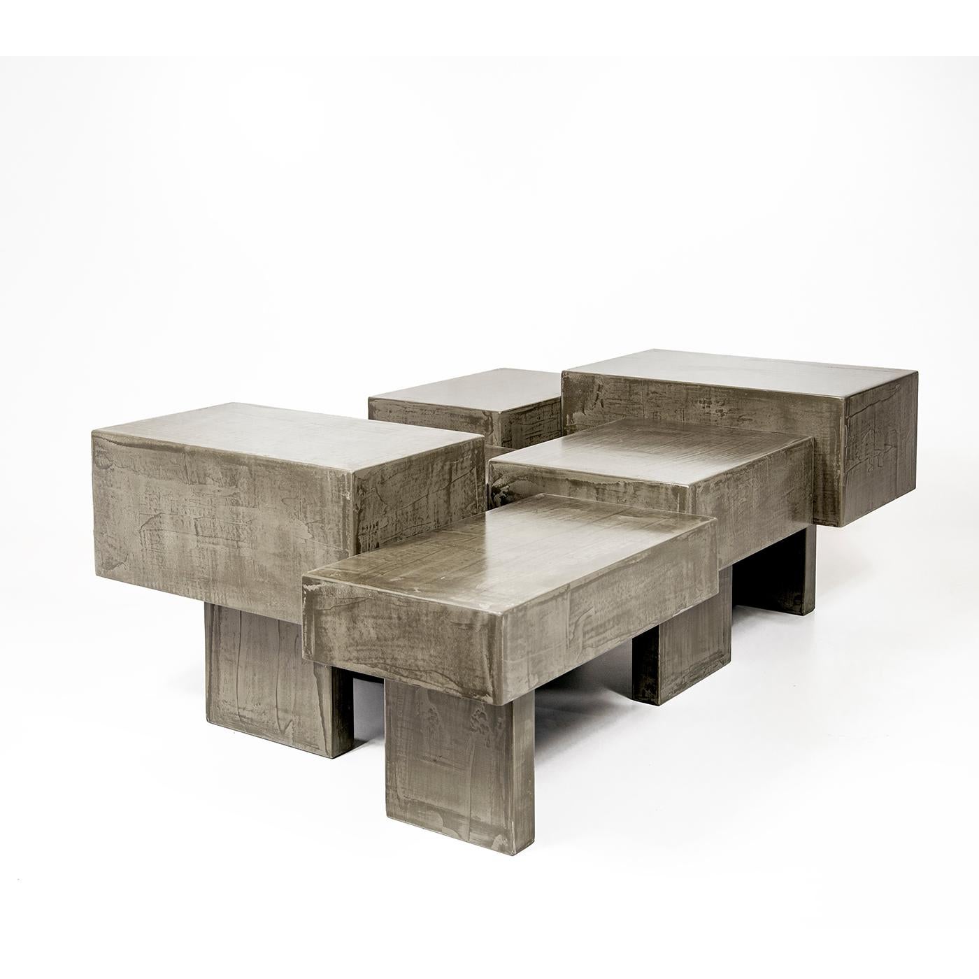 Inspired by the structural posts supporting a building above the ground, this coffee table is composed of individual sections of cement-covered wood set together in a scattered arrangement. The brushed light gray color and polished finish enhance