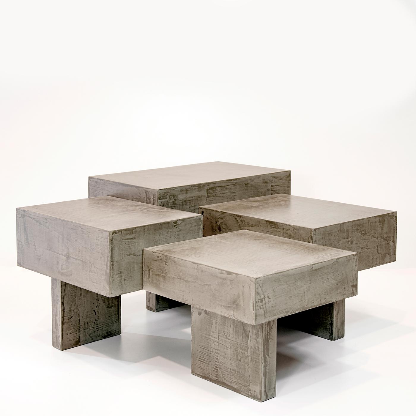 An interplay of geometries and perspectives, this impressive coffee table has a captivating, architectural design that introduces a unique atmosphere in a contemporary and eclectic interior decor. Made of wood covered in brushed light gray cement