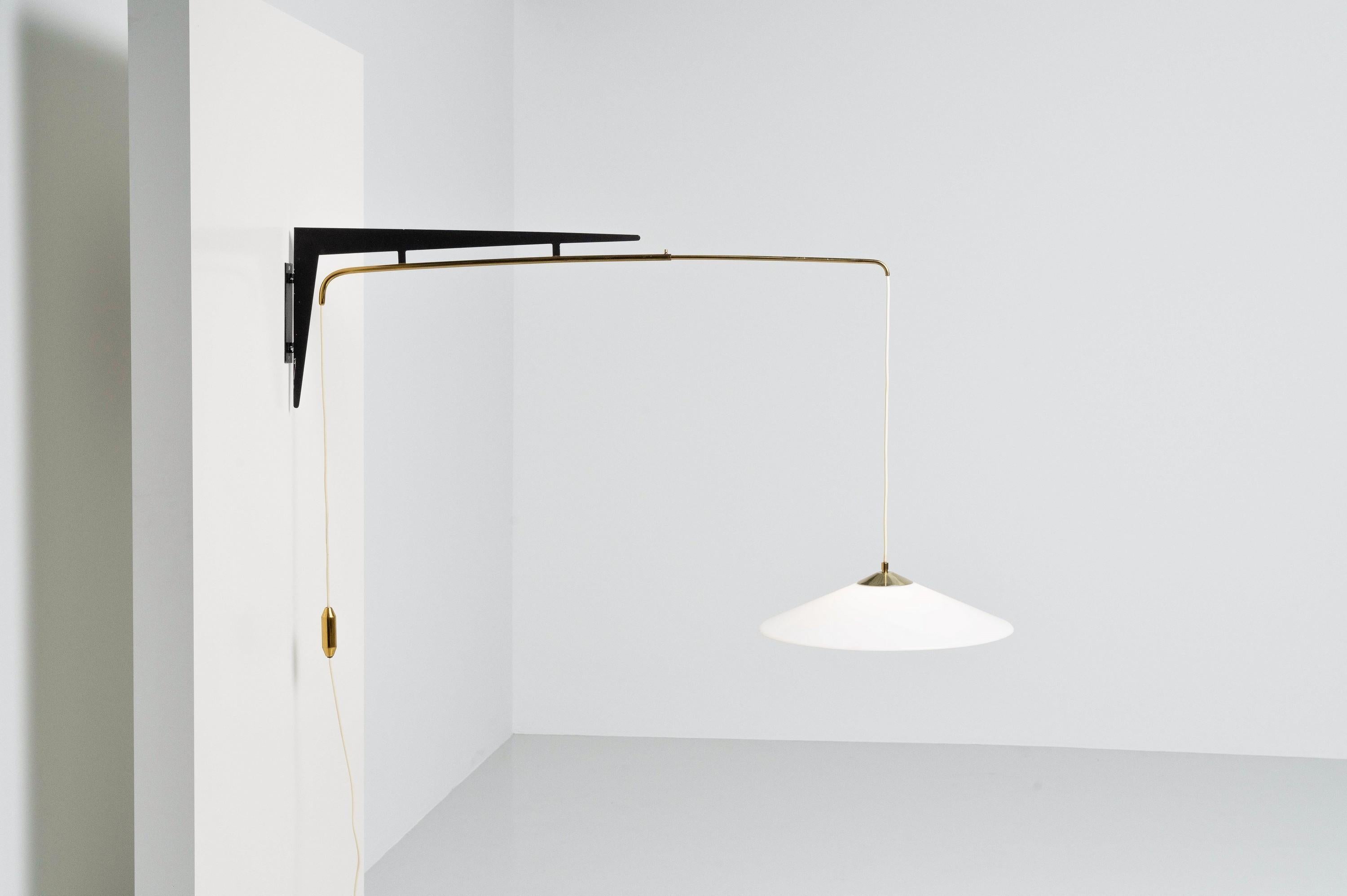 Very clean looking adjustable wall lamp made by Stilux in Italy in 1960. This wall mounted lamp has a small brass counterweight, and can be easily swinged sideways. The fixture itself containing two brass rods can be adjusted and fastened as one