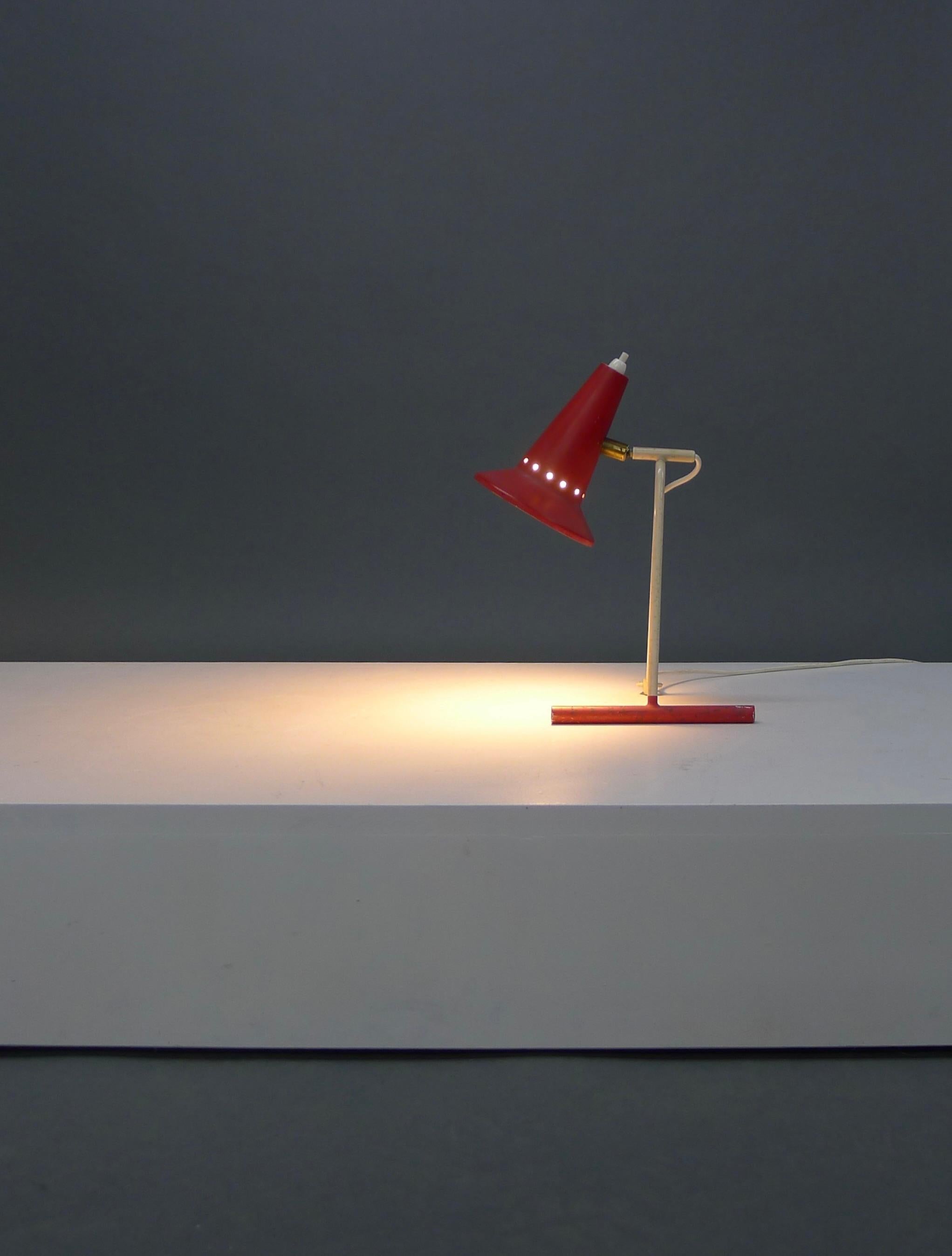 Stilux desk lamp, Italian 1950s

In lovely original condition, the red painted cone shaped metal shade has a band of perforations allowing light to shine through. The ball-jointed neck rotates the shade to where light is needed, and the plastic
