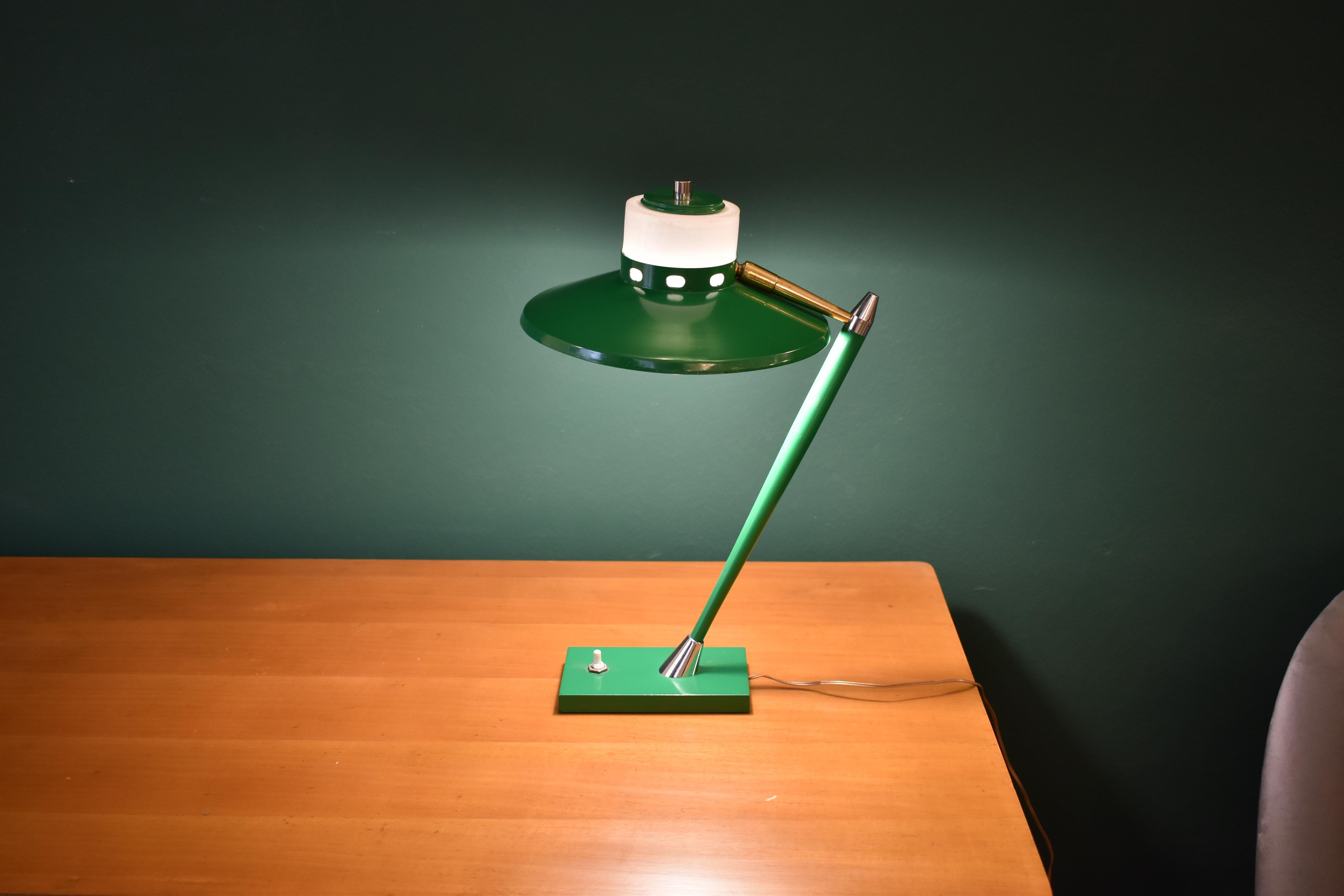 Elegante lampada da tavolo o da scrivania di Stilux, di colore verde brillante e moderna, con paralume regolabile e pulsante alla base. Questo superbo design è messo in risalto da dettagli metallici in ottone e argento.
Italia. 1950s
Il cavo è