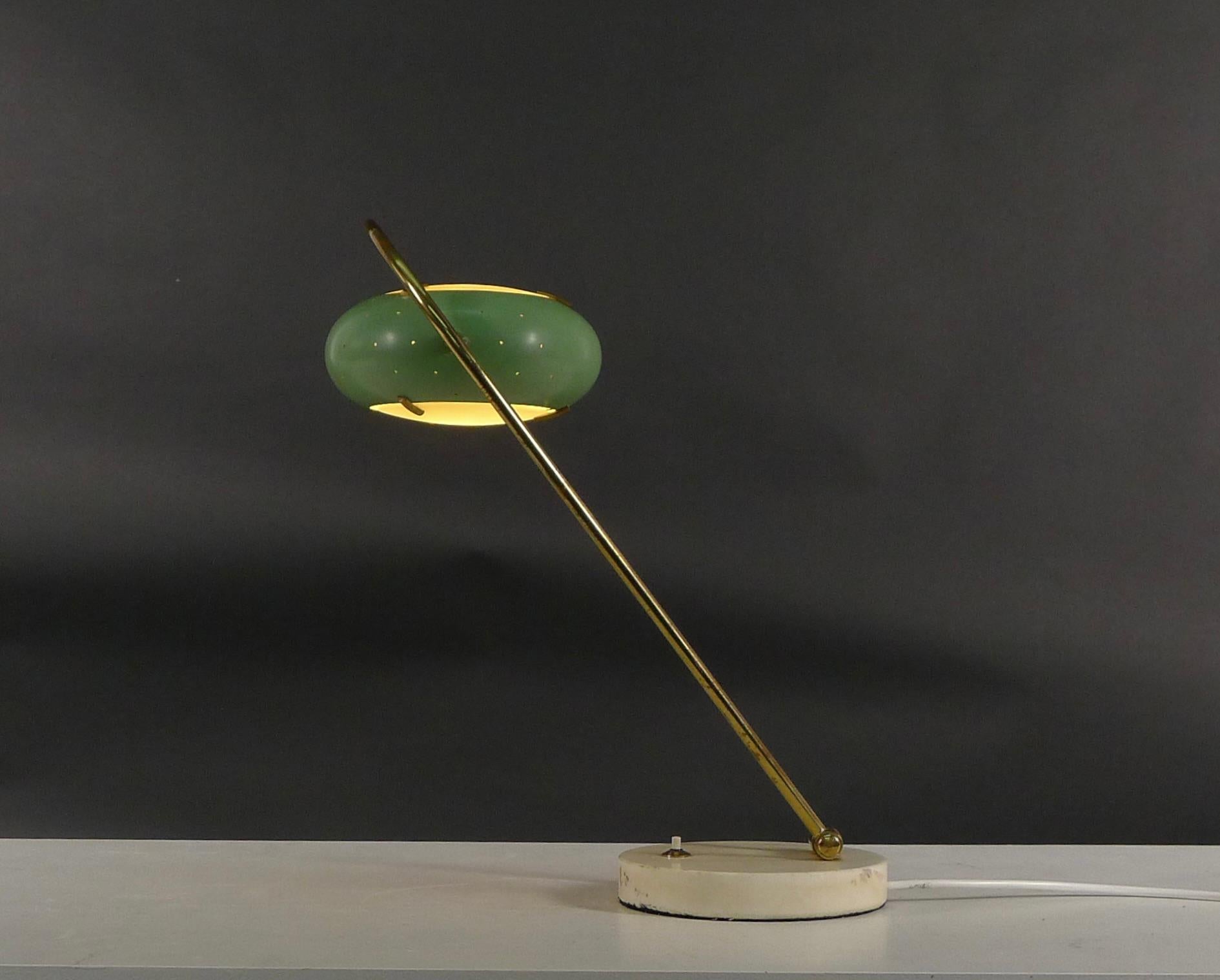 Stilux adjustable desk or table lamp, dating from the 1950s.

Fully adjustable, with perforated green enamelled shade inset with glass discs suspended within a brass hoop support on circular white marble base.

Both the shade and the brass support