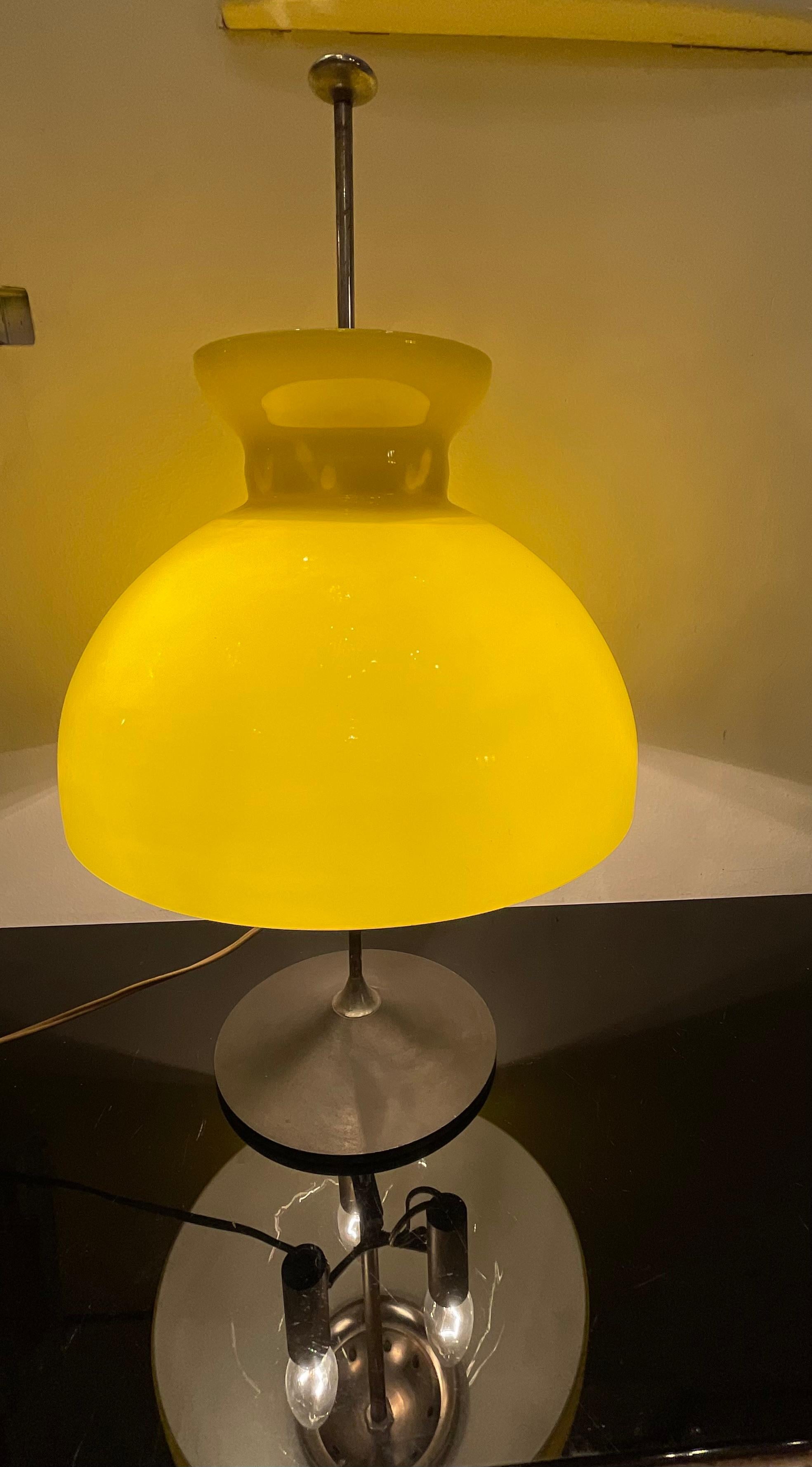 A lamp by the firm STILUX, produced in the 1950s, in ITALY, its lampshade is made of yellow-enameled murano glass on the outside and white on the inside.
The metal and chrome frame has a button that when pressed allows the glass shade to be raised