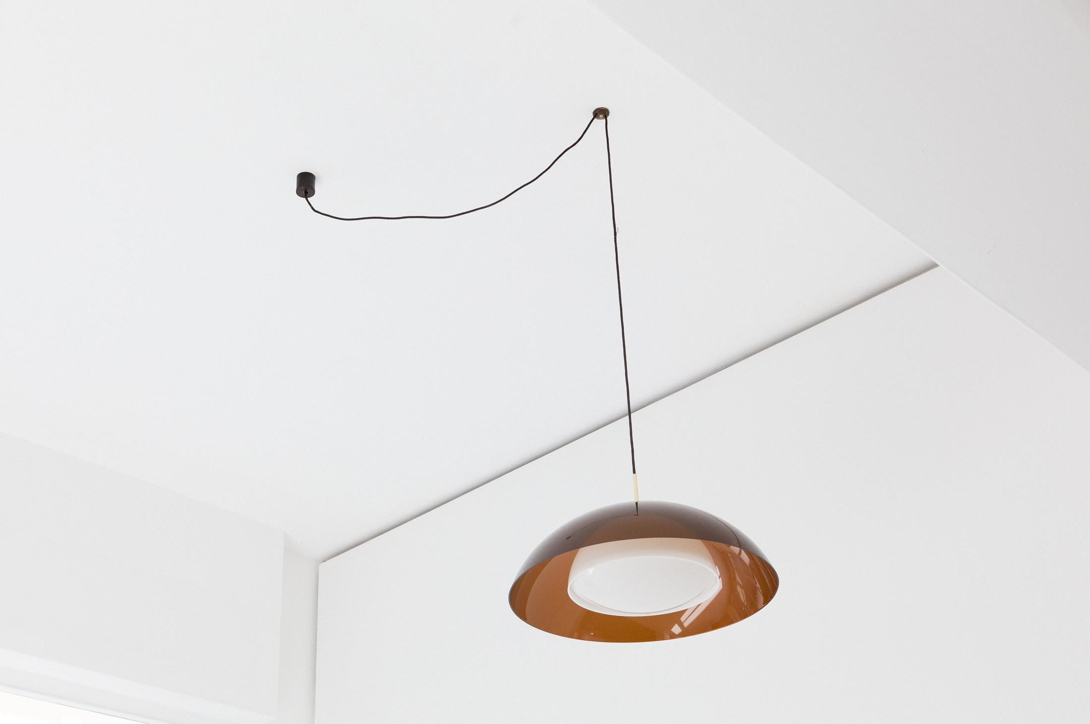 Mid-Century Modern pendant lamp, designed and manufactured in Italy by Stilux Milano in the 1960s.
Made of coffee color plexiglas, brass details and opaline Perspex.
A comfortable hook to the ceiling allows, if you want, to place the chandelier