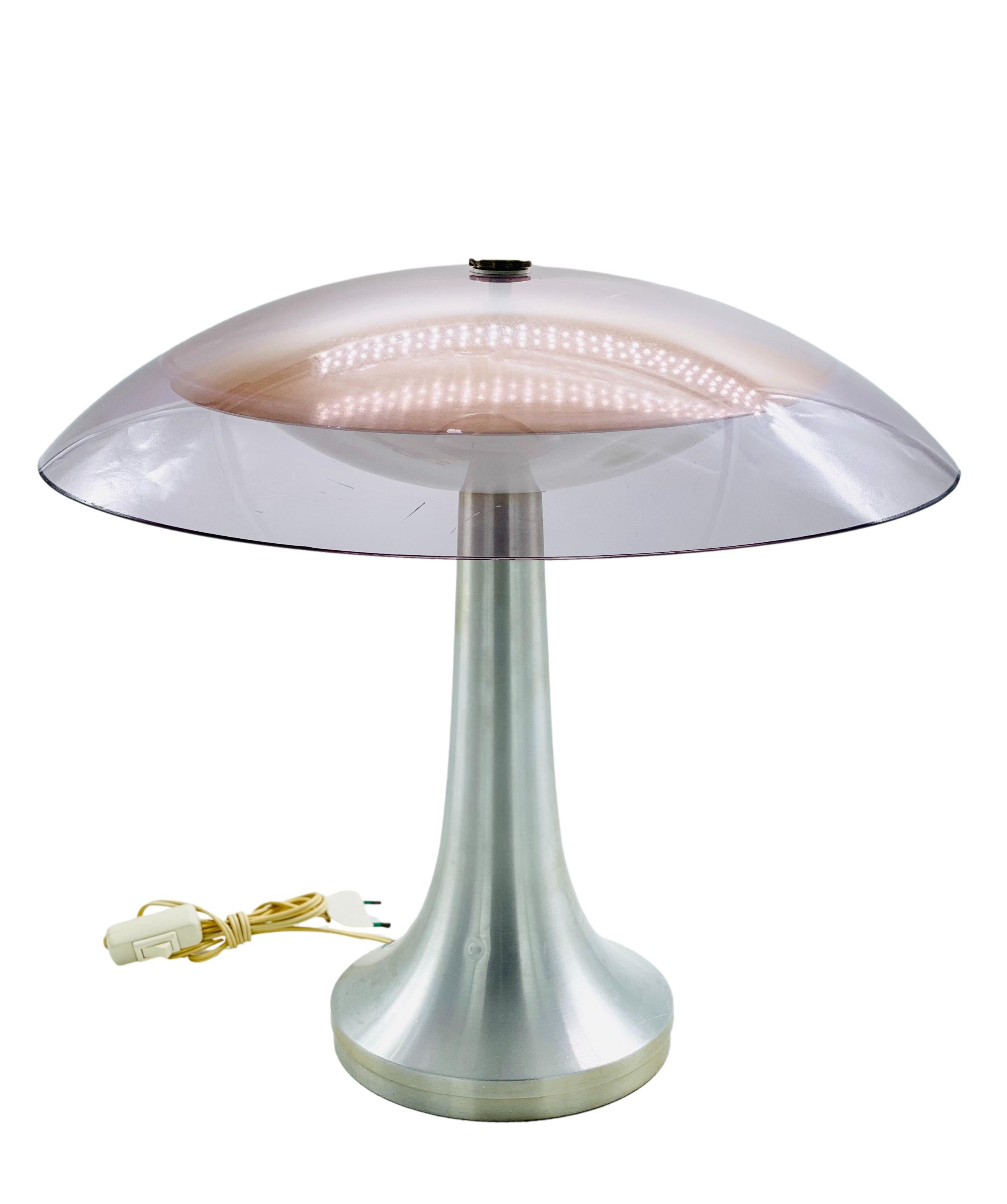 A table lamp with a brushed aluminium base and mauve plexiglass diffuser, the lamp was designed in the 1970s and produced by the prestigious Stilux Milano in Italy. Defects on the diffuser as seen in the photos.