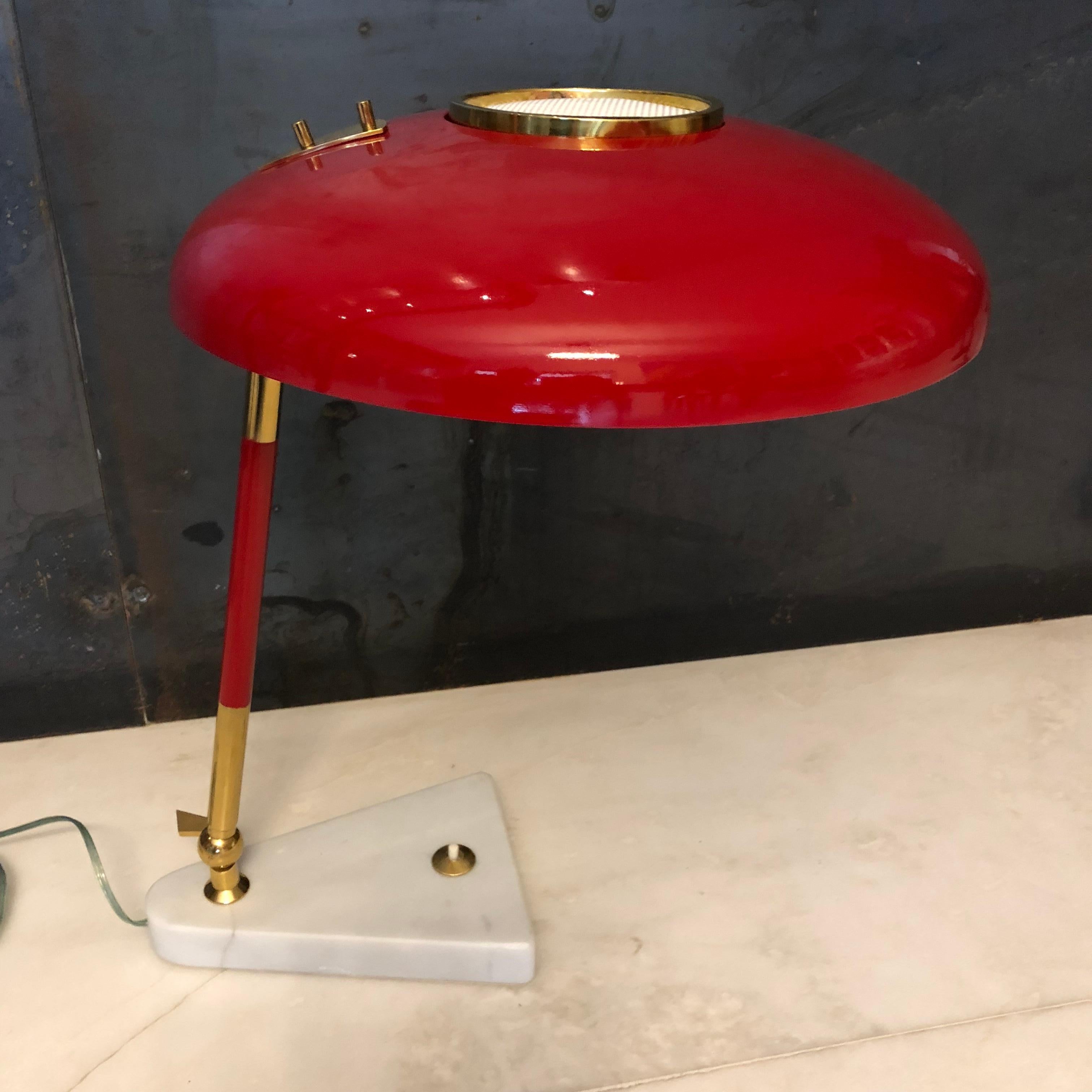 This piece was produced by the Italian brand Stilux Milano during the 1950s. It is an articulated desk lamp with a marble base, a brass structure, and a lacquered aluminum diffuser. It has been rewired to EU standards.