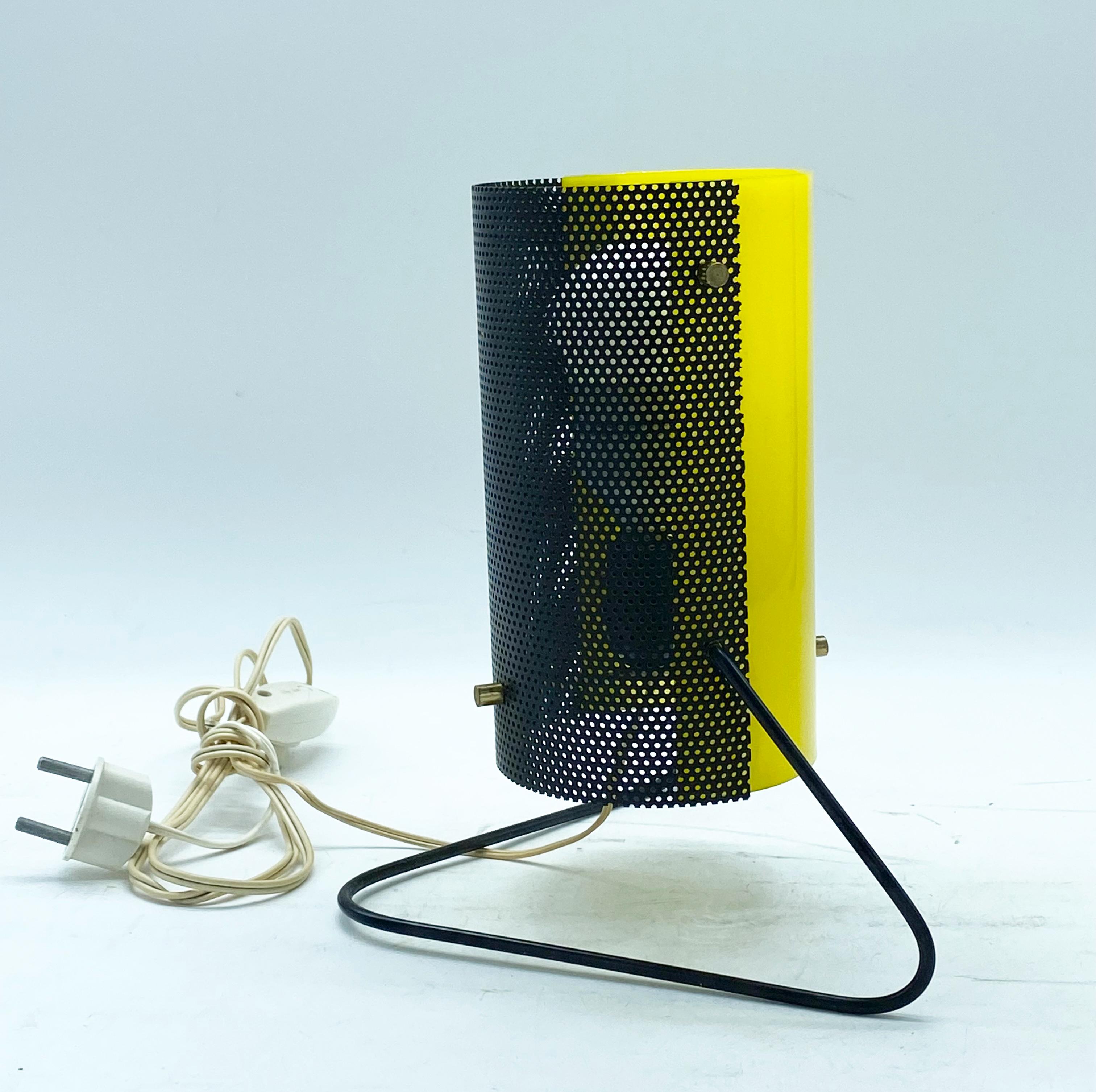 Rare Stilux Milano 1960s perforated metal table lamp. This tiny, quirky design echoes those of Mathieu Matégot, but with a typically Italian 1960s twist. Executed in perforated black painted metal, clean yellow perspex, brass hardware on a