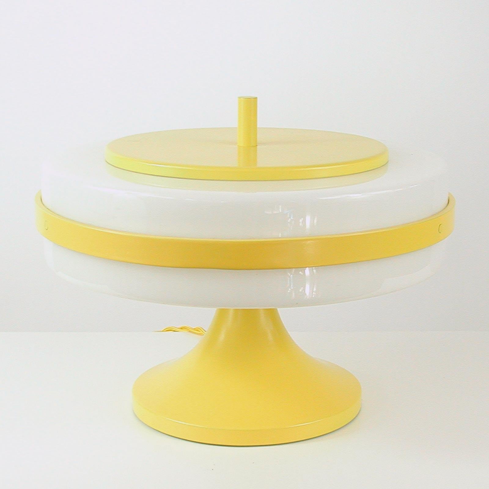 This extremely rare and unusual Stilux Milano Space Age Saturn table lamp was designed and manufactured in Italy in the late 1960s-early 1970s. The lamp features a tulip shaped base and a white Lucite (plastic) lamp shade with yellow lacquered