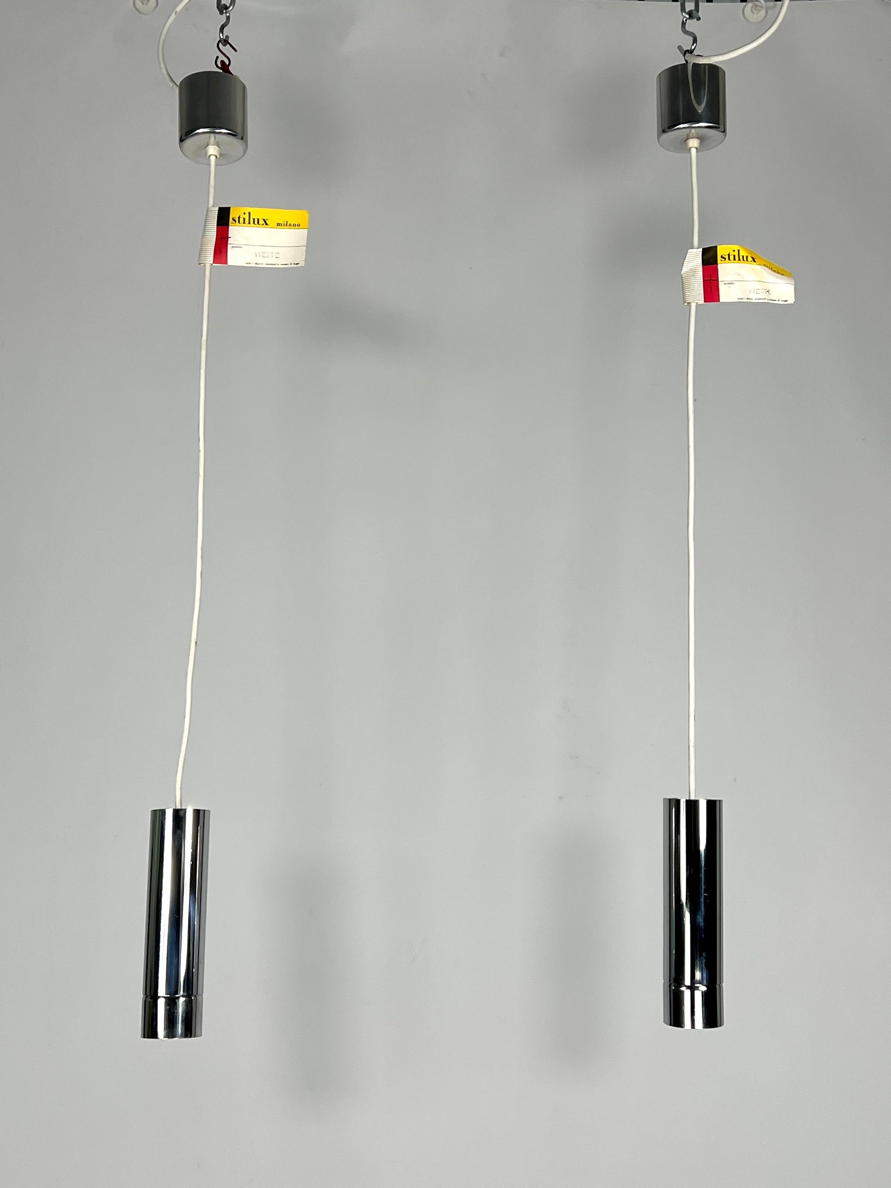 Excellent vintage condition for this set of two pendant lamps produced by Stilux Milano during the 70s. Made from chrome. Labeled. Full working with EU standard, adaptable on demand for USA standard.