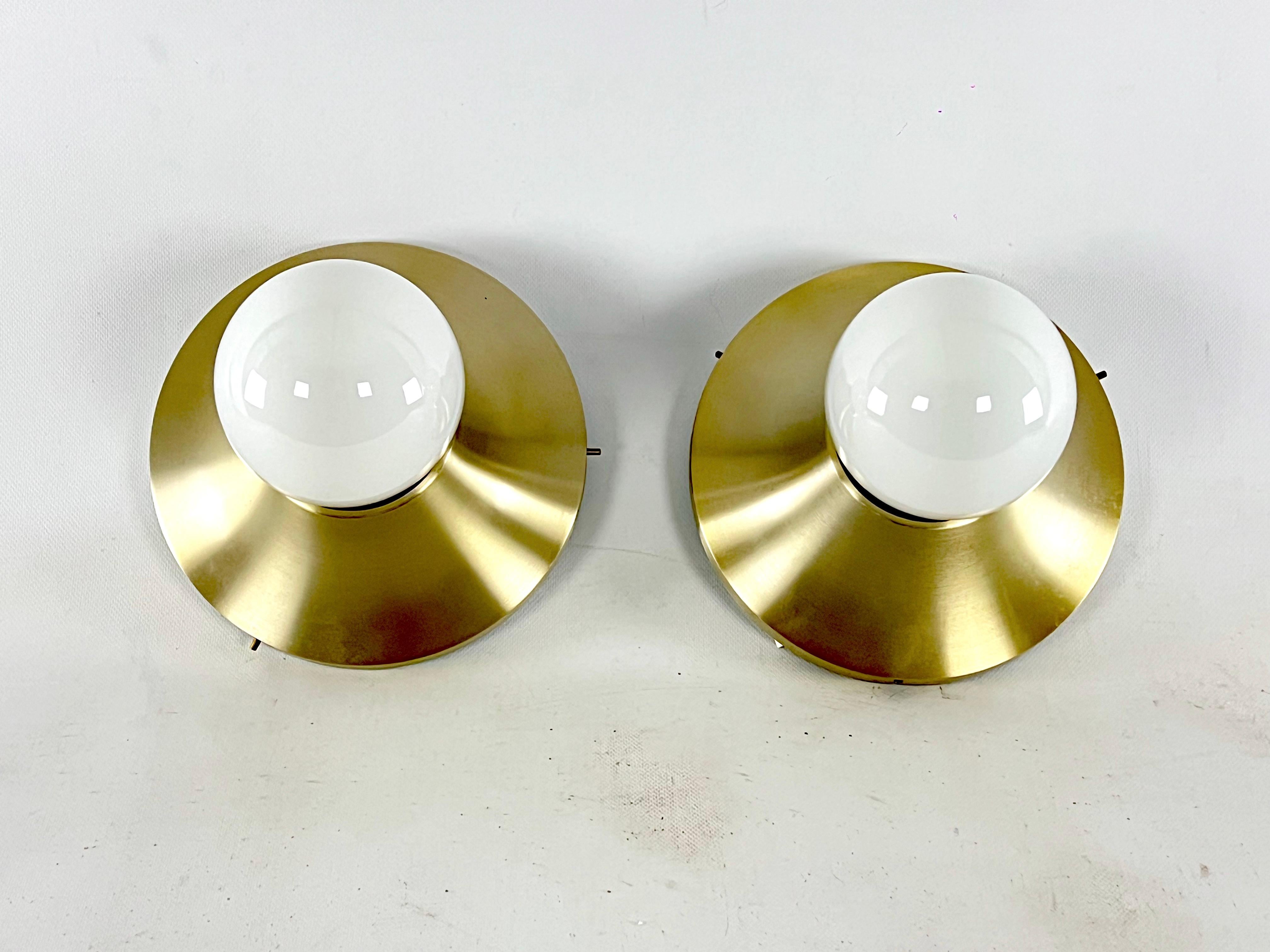 Vintage condition never used for this set of two wall lamps, model Sassari, produced and signed by Stilux Milano. Made from polished gilded aluminum. Never used, they still have the original tag. Height considered without bulb. Full working with EU