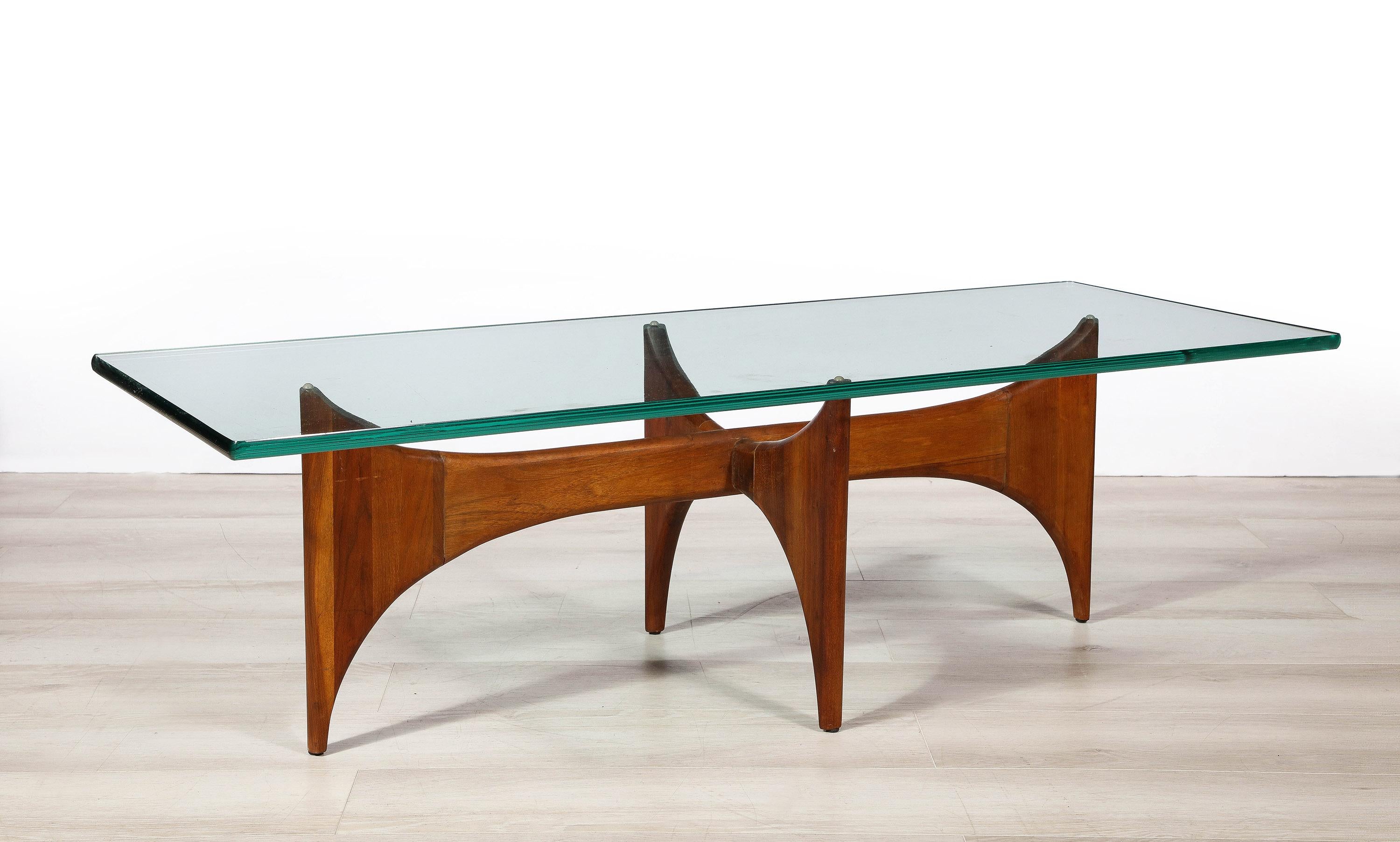 Coffee table with sculpted walnut base with glass top.