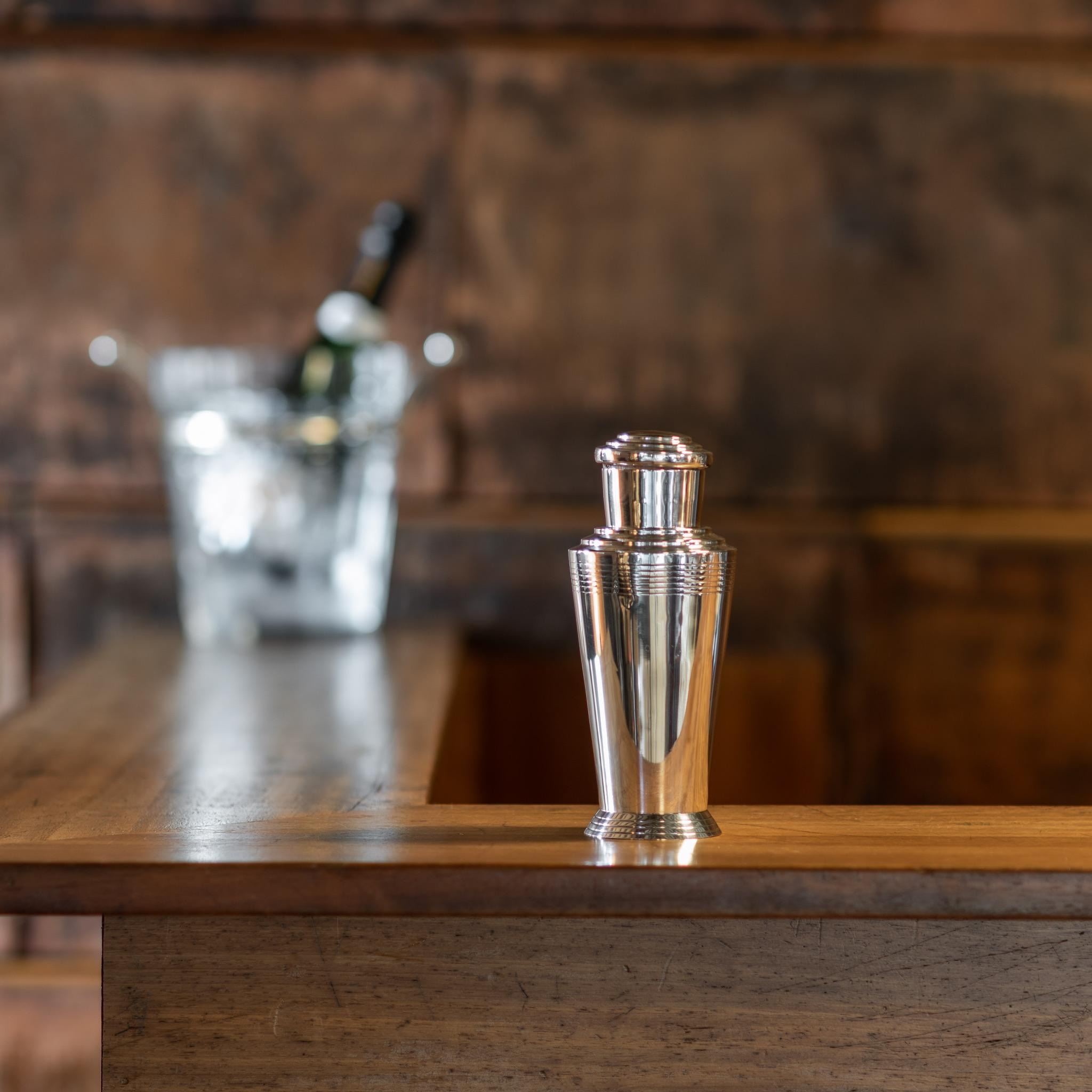 Art Deco cocktail shaker, with stepped and lined decoration to the top and body of the shaker, by Keith Murray for Mappin and Webb. Hallmarked Sheffield 1932. The cocktail shaker has a one pint capacity, with a cork filled lift-off cap and removable