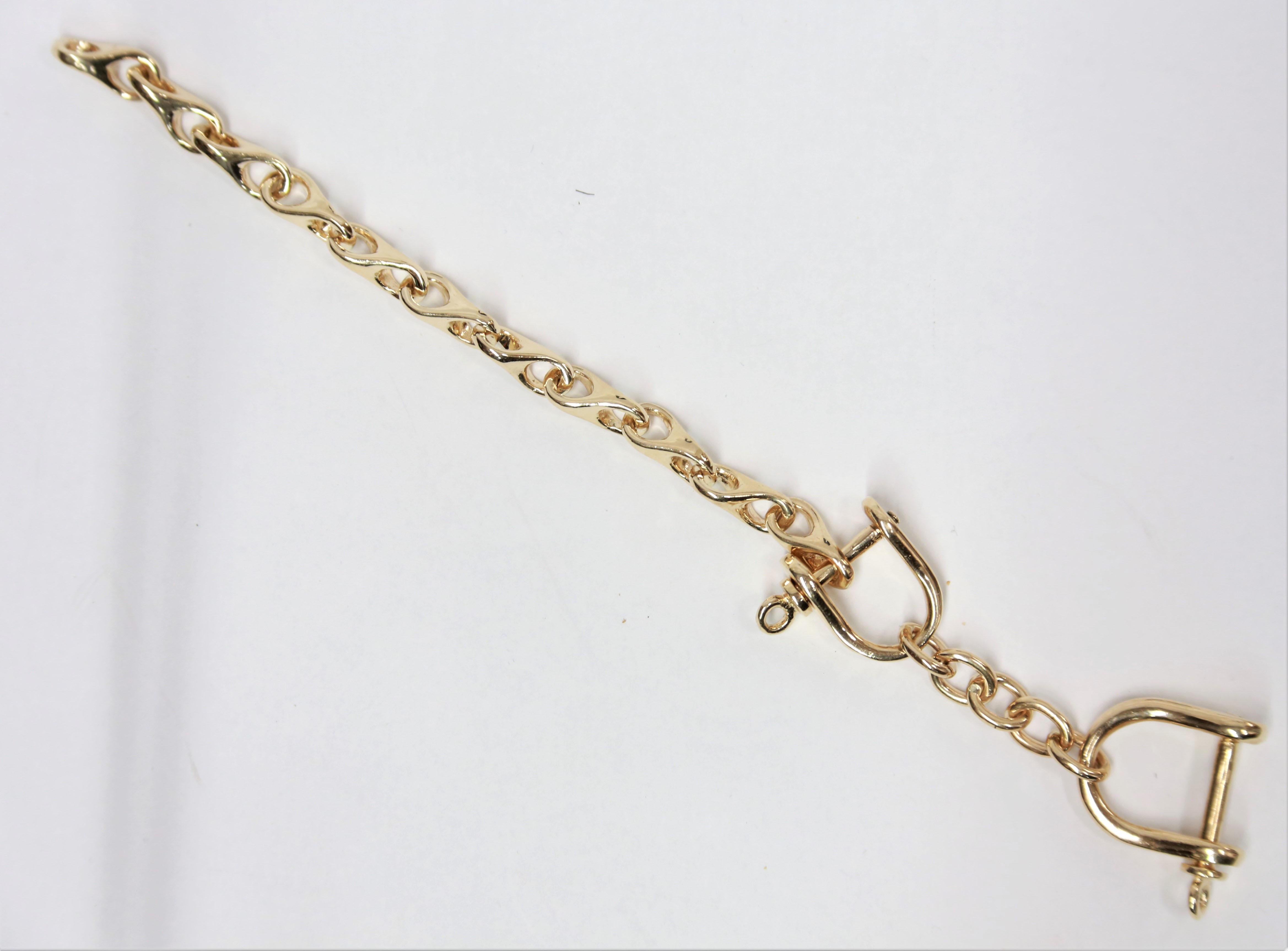 Iconic Gold Stirrup Bracelet; Hand crafted in heavy solid 14 Karat yellow. Bracelet measures approx. 8.5
