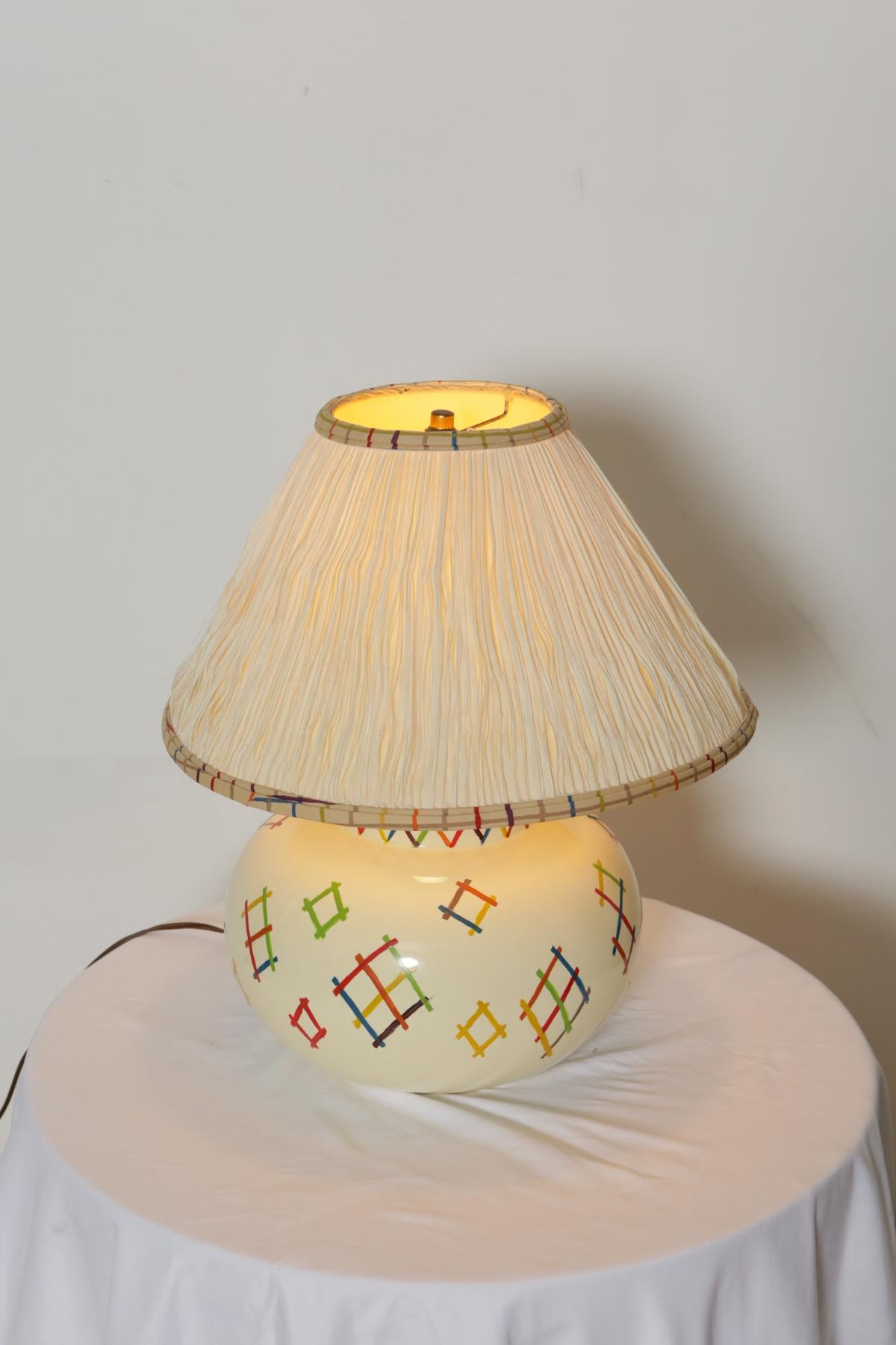 Stitch pattern hand painted table lam.

A classy off-white ceramic base table lamp with beautiful colorful patches design and white shade. The hand painted design features red, blue, yellow and green stitch like patterns. Fashionable and timeless,