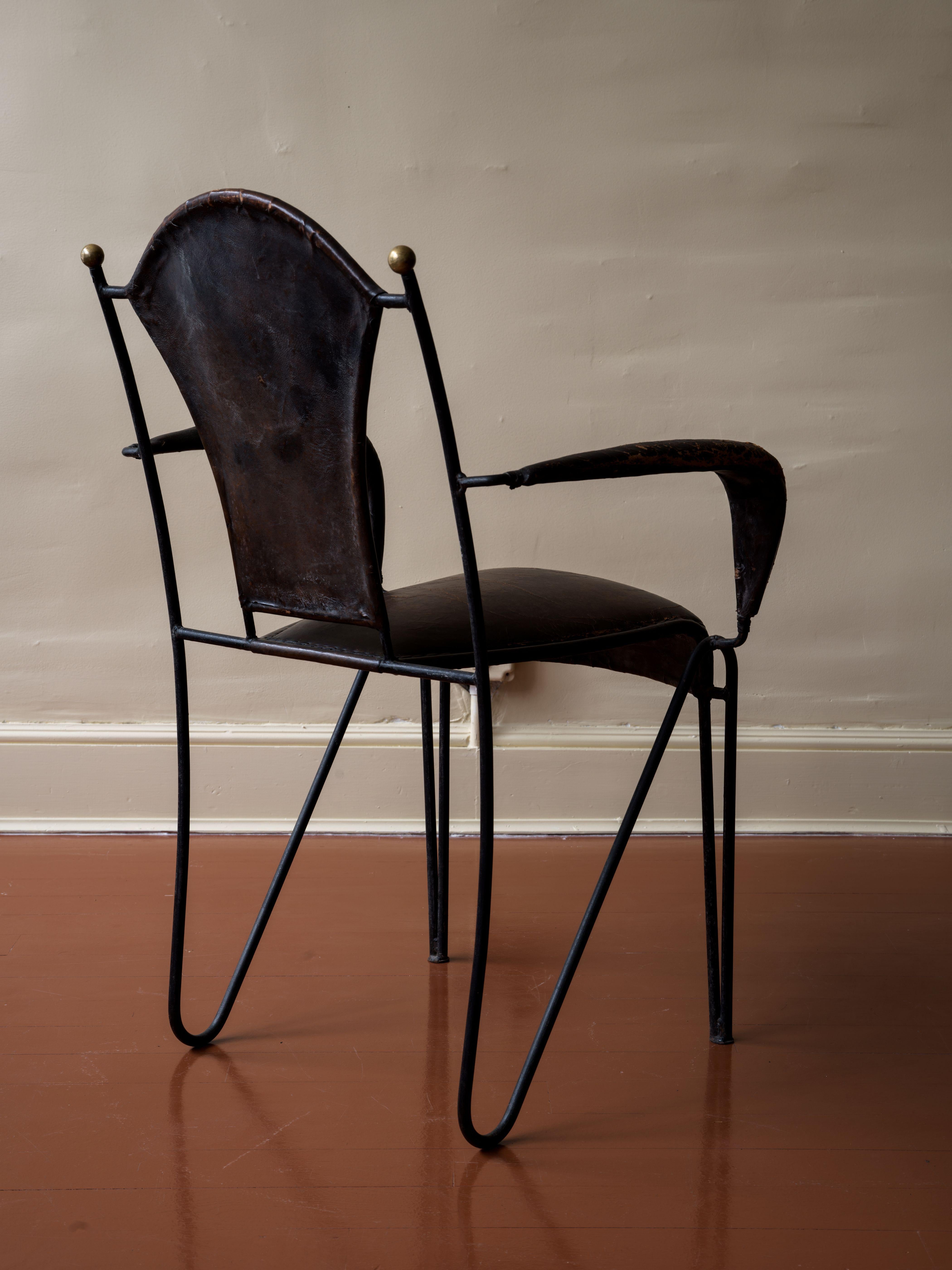 This skillfully stitched leather armchair with rolled arms and ironwork is attributed to Jacques Adnet, a French and Hungarian architect and designer. The leather has developed a patina over time and the iron is in excellent condition. On the ends,
