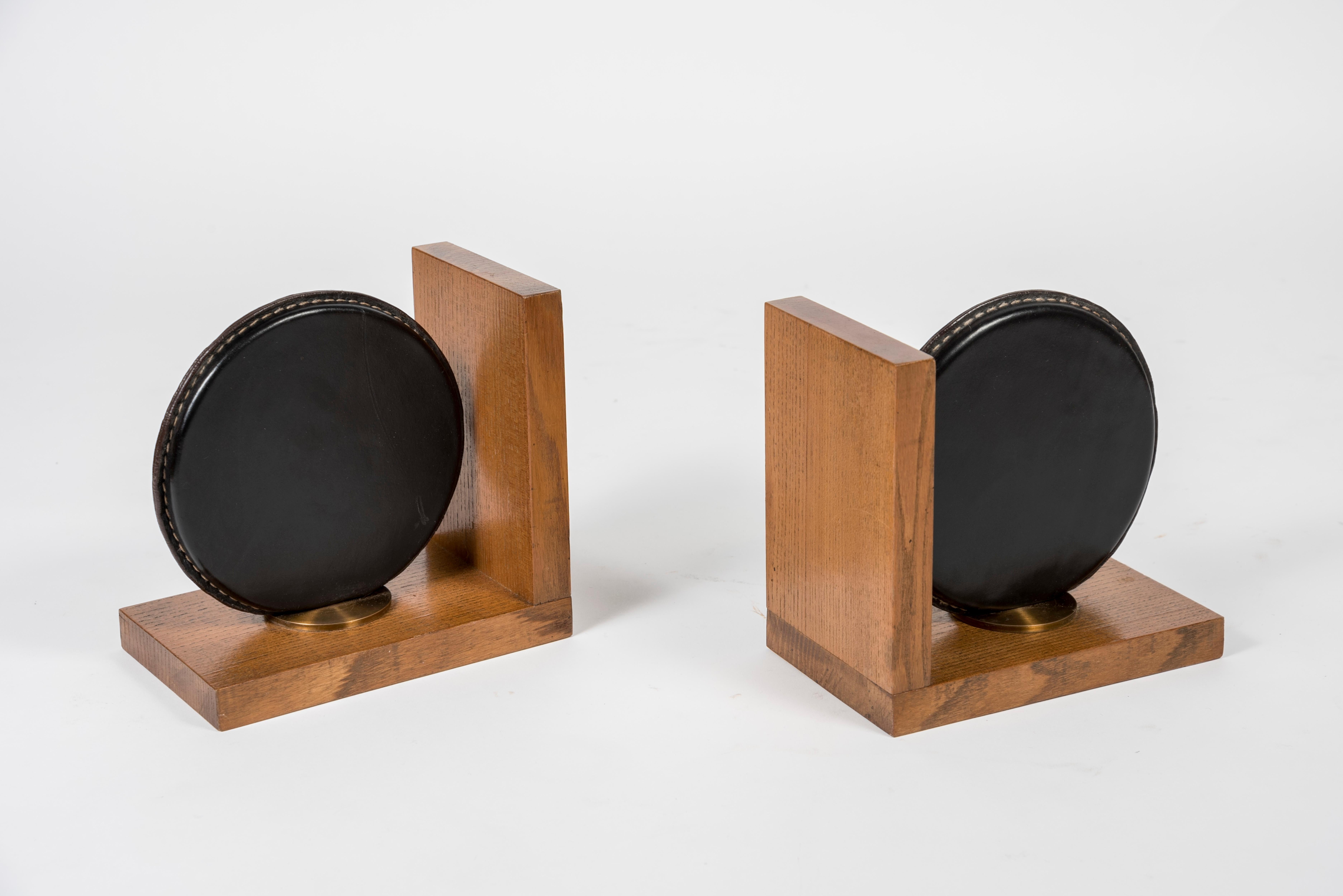 Stitched leather and oak bookends by Jacques Adnet.