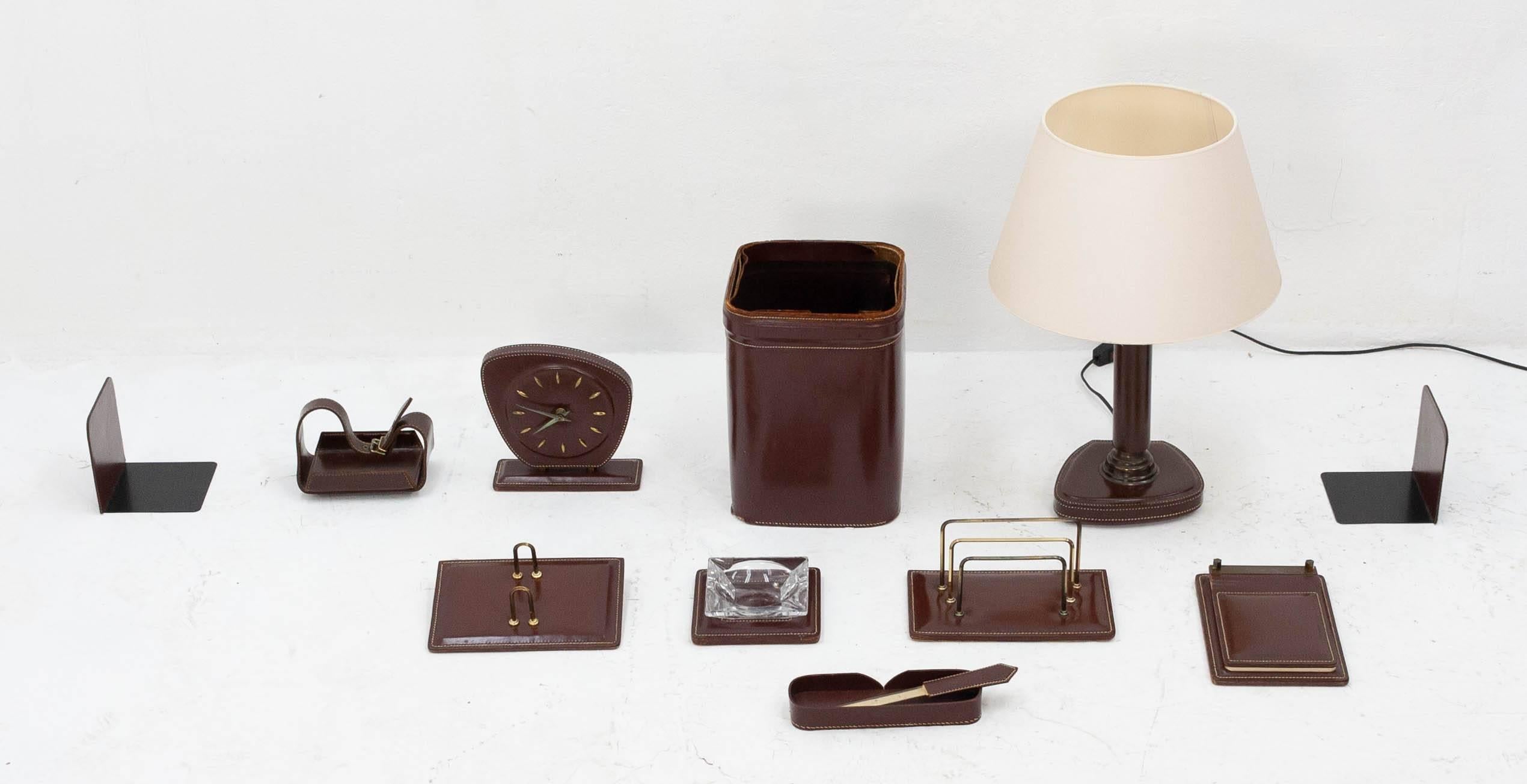 Fabulous large stitched brown leather desk set, French, 1960s. This set consists of the following eleven items:

- Desk clock (in good working order)
- Two bookends
- Letter holder
- Business card holder
- Desk lamp with lampshade
- Glass