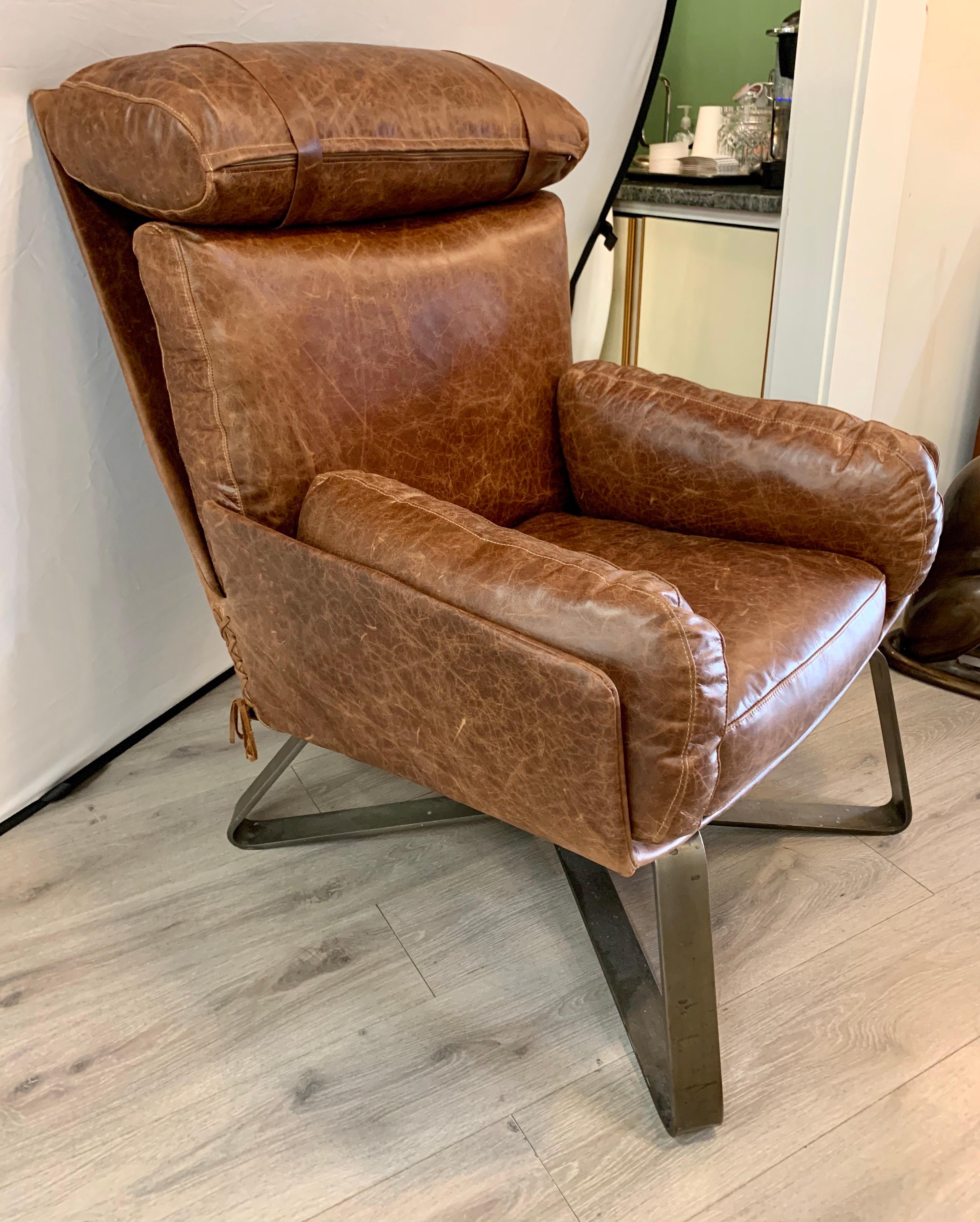 Elegant stitch brown leather chair. Stitching runs up the side. Features metal base. Now more than ever, home is where the heart is.
