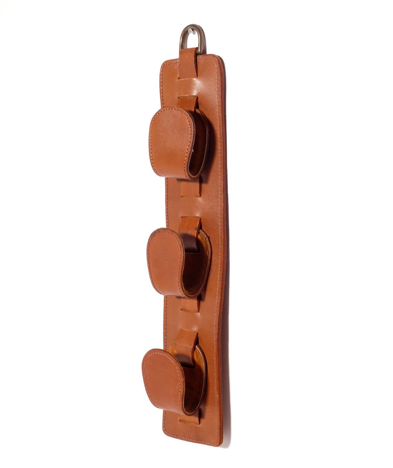 Stitched leather magazine holder attributed to Jacques Adnet, unsigned, France, circa 1960s. This piece is a versatile size and can be used to hold magazines or newspapers, or to hold other lightweight items such as dog leashes or as a coat hanger.