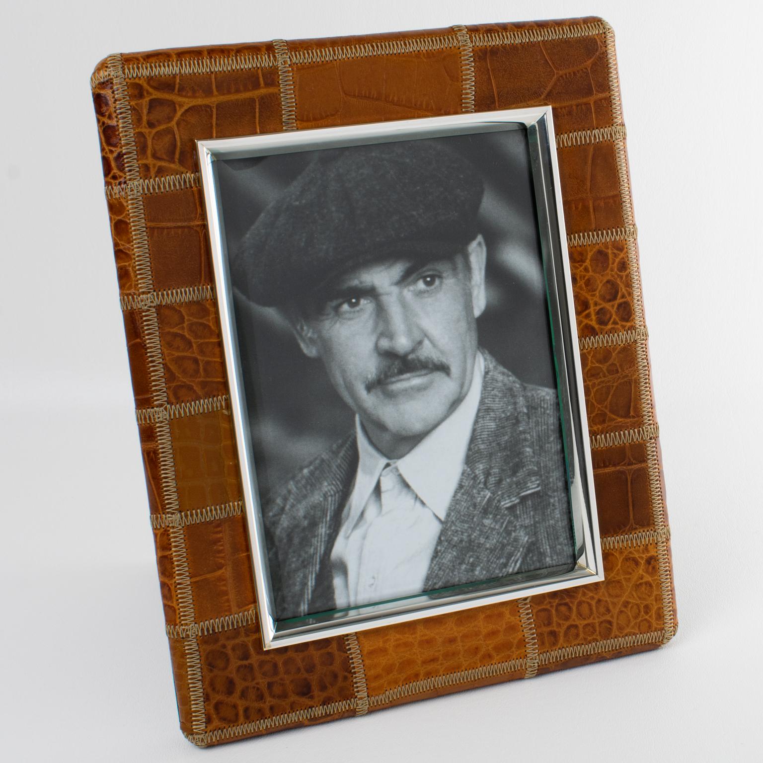 El diseñador italiano Del Conte creó este lujoso marco de fotos de cuero y cromo. Esta rara pieza se fabricó en Italia hacia 1970. El elegante e intemporal lagarto marrón especia y el cuero repujado se adornan con una construcción de patchwork