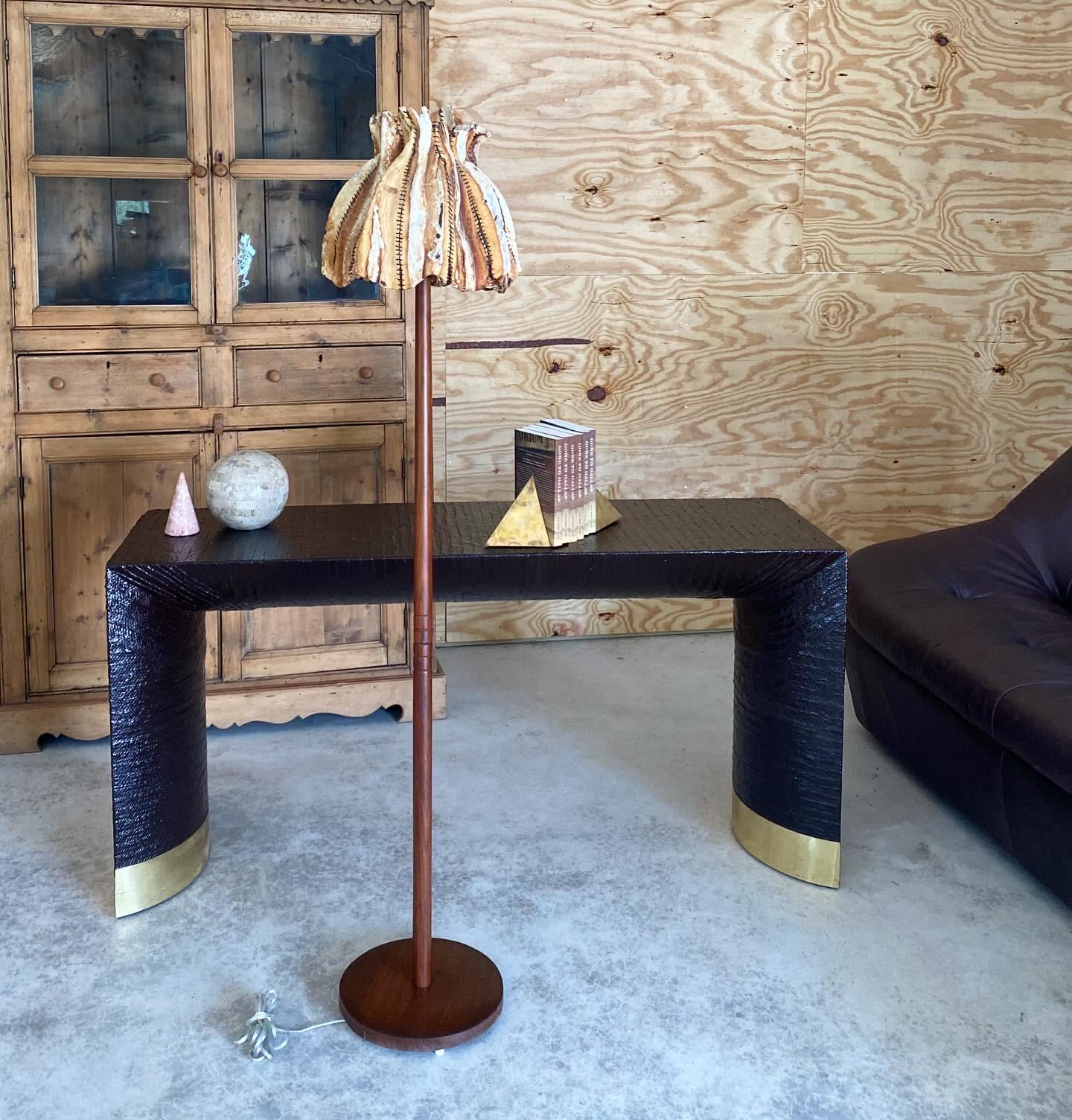 Hand-stitched rawhide shade on turned floor lamp base in solid teak. The shade is an absolutely stellar piece of folk art. The artist created a sculptural work of art by stitching strips of dried rawhide leather together into a lampshade. We've