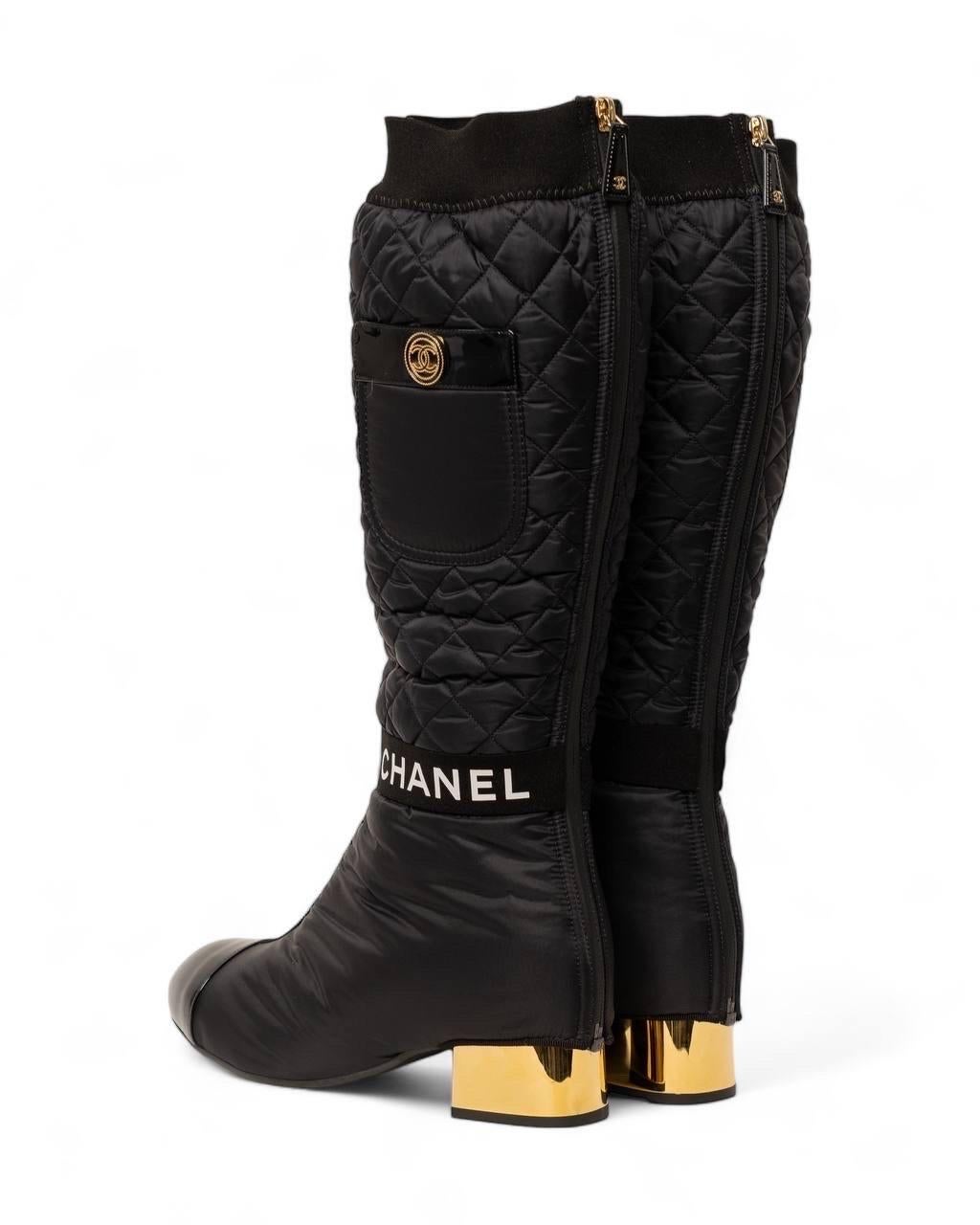 Stivale firmato Chanel, modello Double, realizzato in nylon trapuntato con rifiniture in pelle verniciata nera e hardware dorati. Presenta un tacco alto 4 centimetri in metallo nella colorazione oro, dotato di una zip logata sul retro. Misura 16
