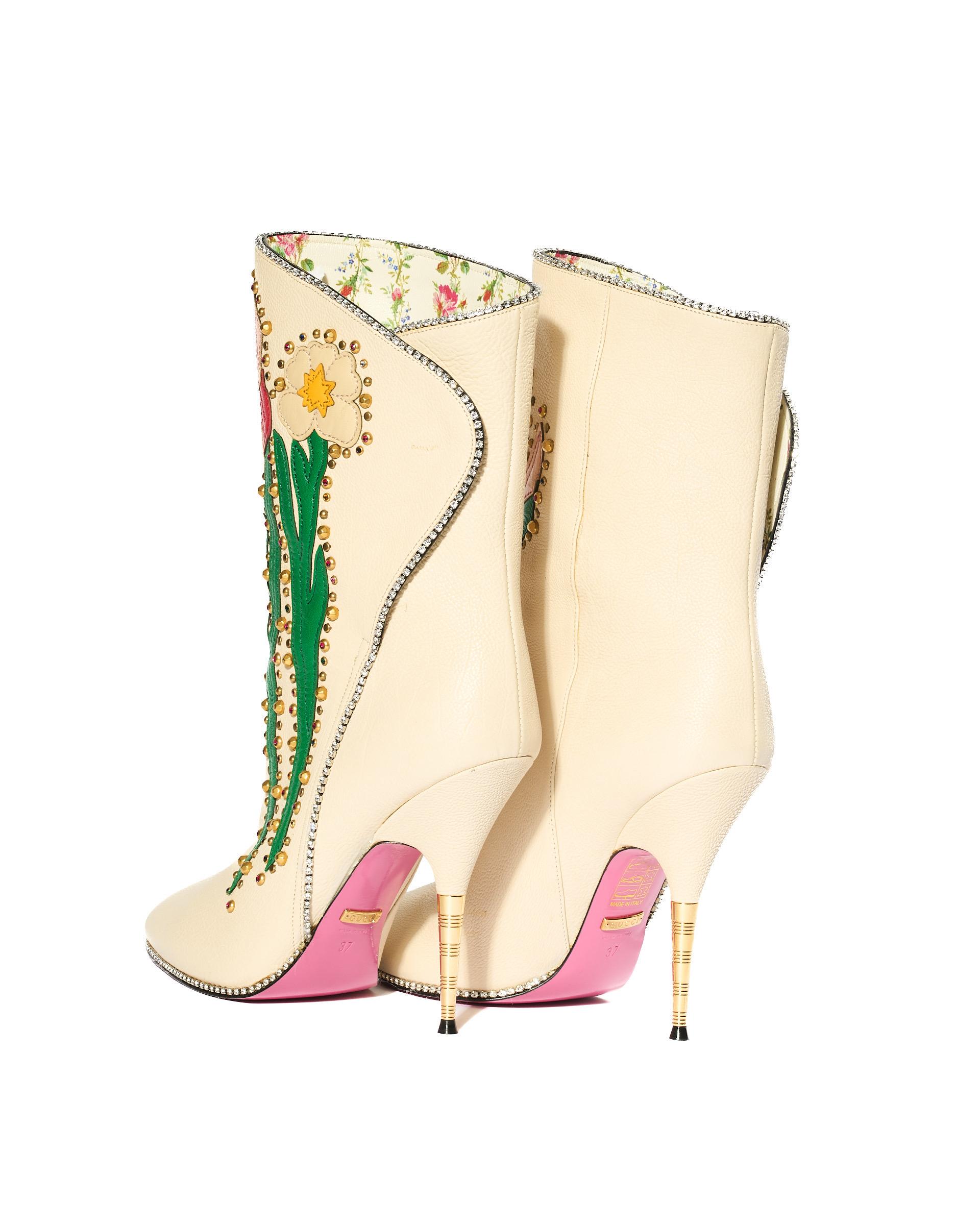 Stivaletti firmati Gucci, modello Fosca Floral, realizzati in pelle nella colorazione beige con  Hardware dorati. Sie haben keinen Verschluss, sondern sind aus Pelle bianca mit floralen Motiven genietet. Presentano sulla parte frontale fiori in