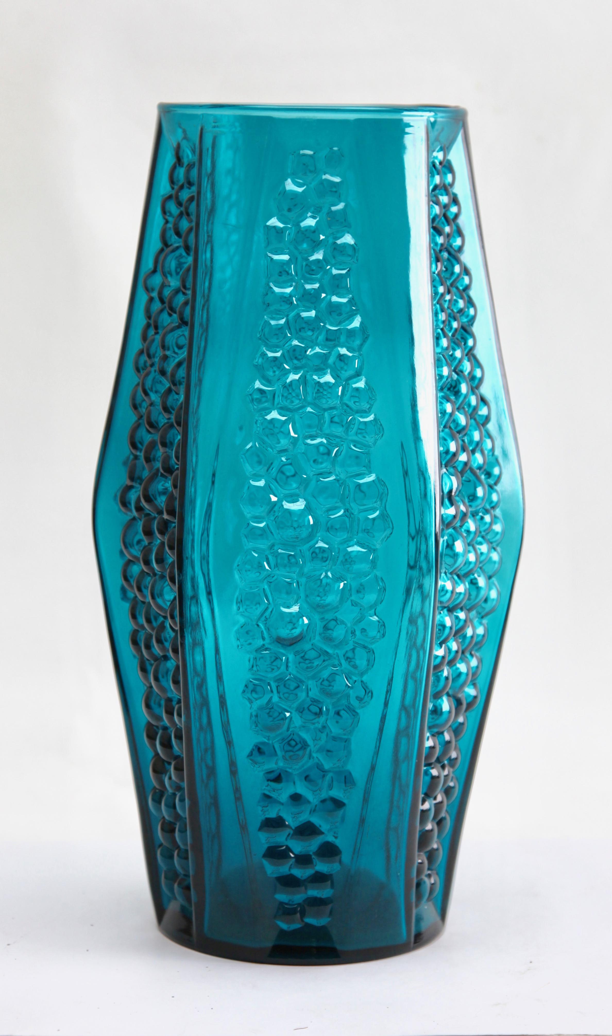 A molded hexagonal vase in sea blue with an eye-catching pattern of bubbles concave indentations. Attributed to the Stolle-Nieman factory (Huty Szklane Niemen, Poland) and made in the 1970s.
While similar designs from Czechoslovakia were made from