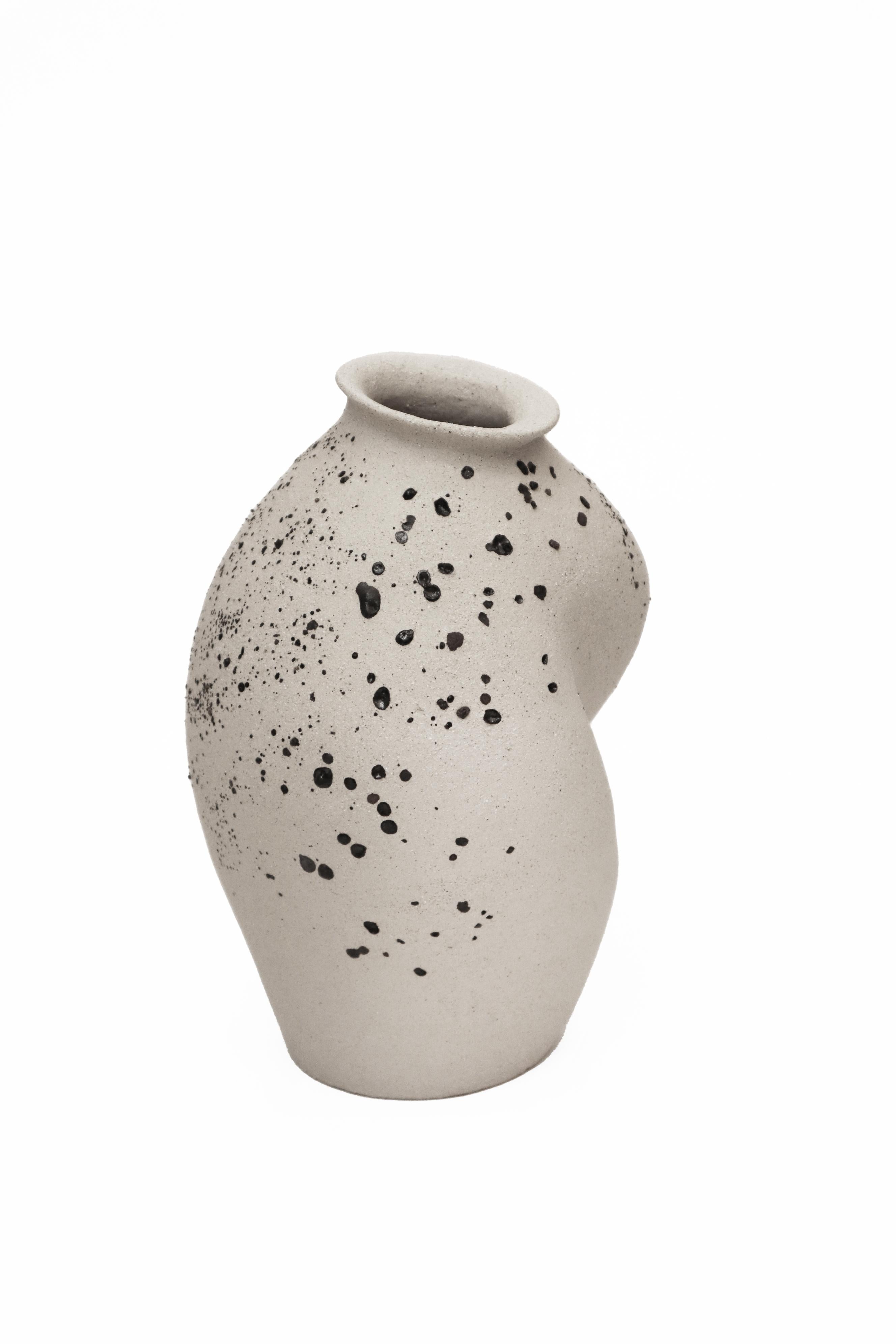 Stomata 4 vase by Anna Karountzou
Dimensions: W 12.5 x D 13 x H 23 cm
Materials: white stoneware clay, clear glaze inside, decorated outside with volcano rocks collected from Santorini, fired at 1240

Born and based in Athens, Greece, with a