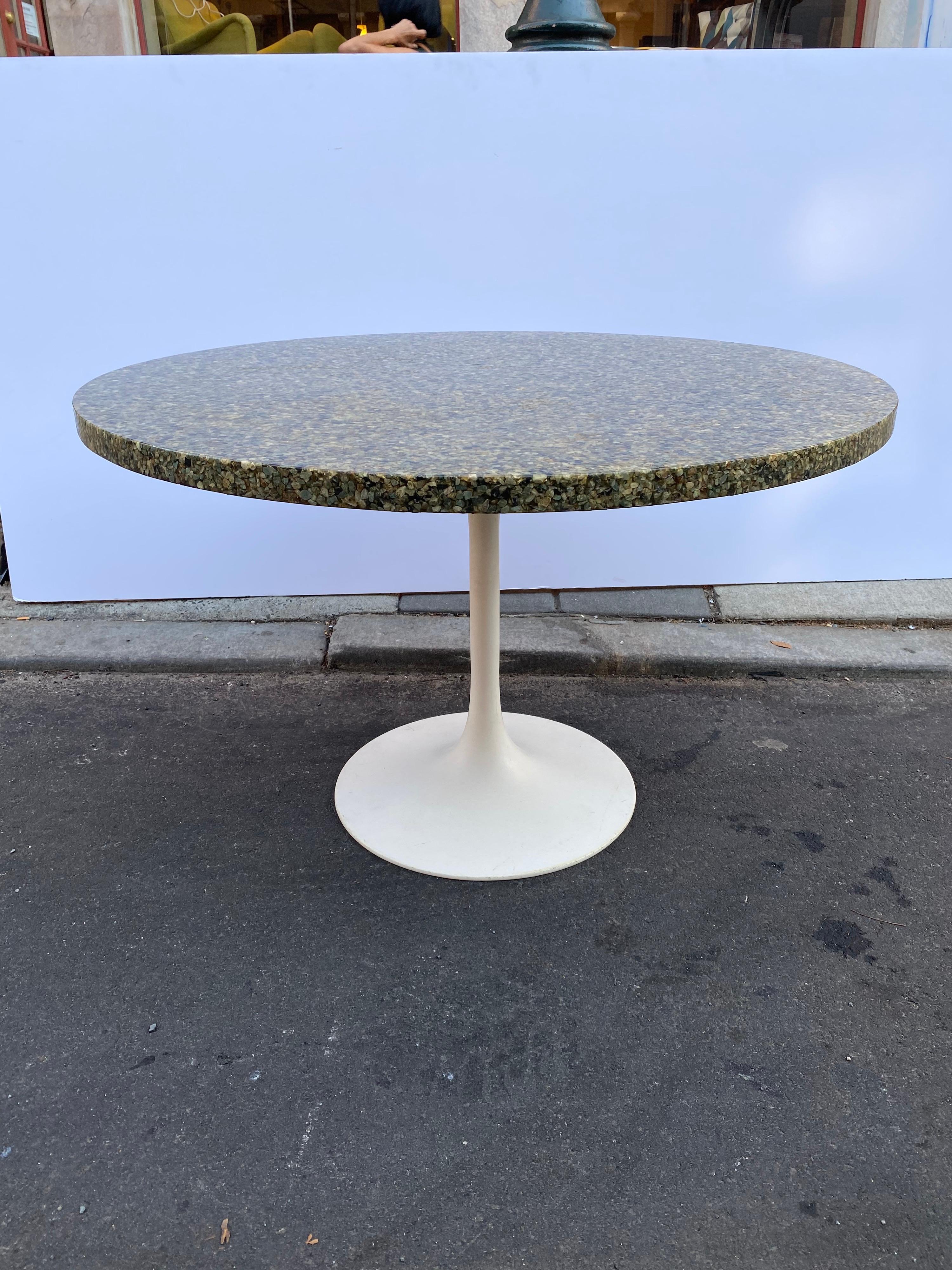 Resin tabletop with stones sitting on a Saarinen style table base. 48