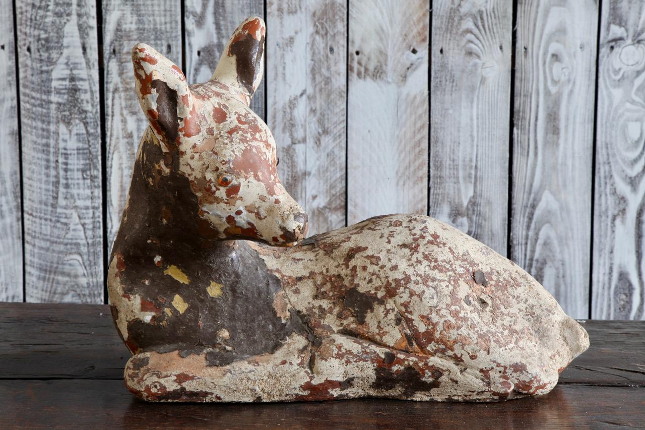 Decorative cast stone fawn with original aged paint work from the 1950s.