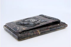 Stone block holder with red tones, silver appliqués, and raised flower lid