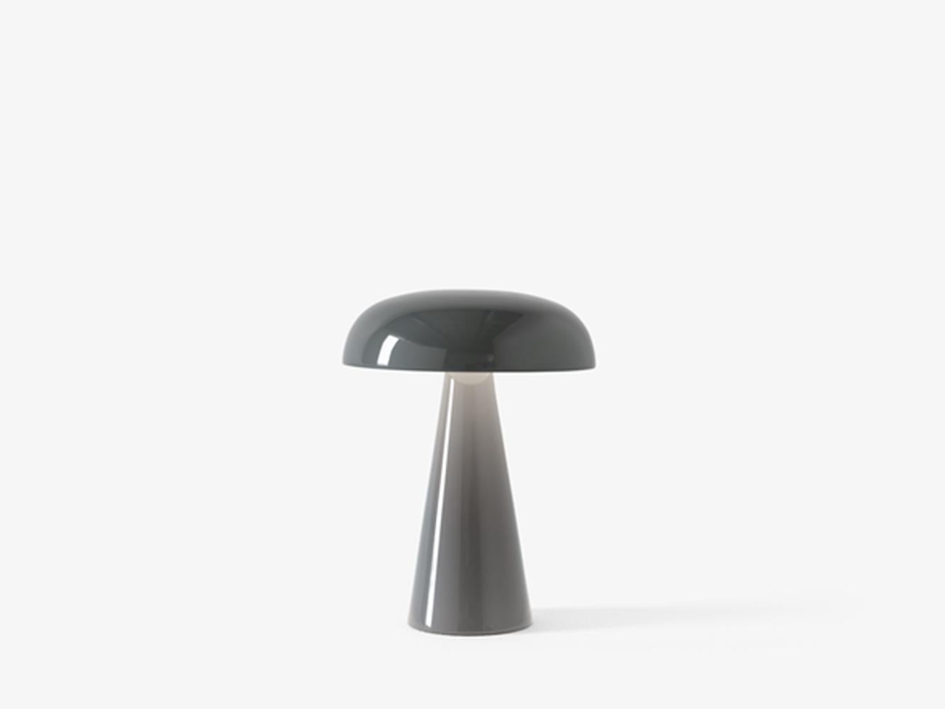 Como SC53, a portable Stone blue table lamp from Space Copenhagen. 
Como’s sturdy base tapers up towards a softy curved, mushroom-shaped shade. 
This battery-powered lamp can operate for eleven hours at the highest setting, with an extra battery